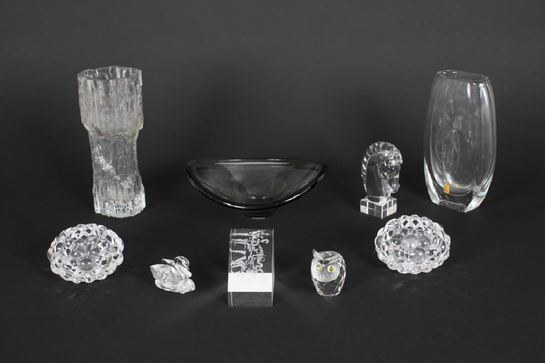 A group of Contemporary glass tabletop items: Including a Steuben glass knight paperweight, a Steuben tennis theme paperweight, a pair of Orrefors votive holders, a Danish Holmegaard dish, a Tapio Wirkkala ice vase, a Swarovski owl, a Swarovski s