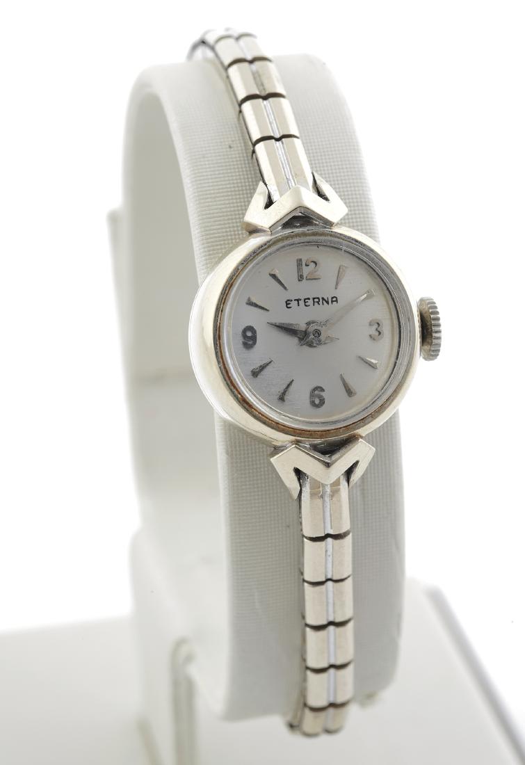 A lady's Eterna 14k white gold wristwatch: DIAL: round, silvered, silver applied Arabic numeral and triangular hour markers, silver dauphine hands, Eterna. MOVEMENT: manual wind (case not opened). CASE: round, 14k white gold, snapbac