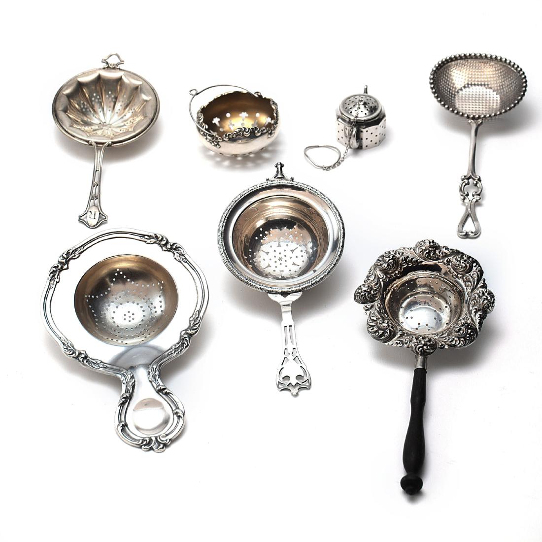 A collection of sterling tea strainers and infuser (1 of 5)