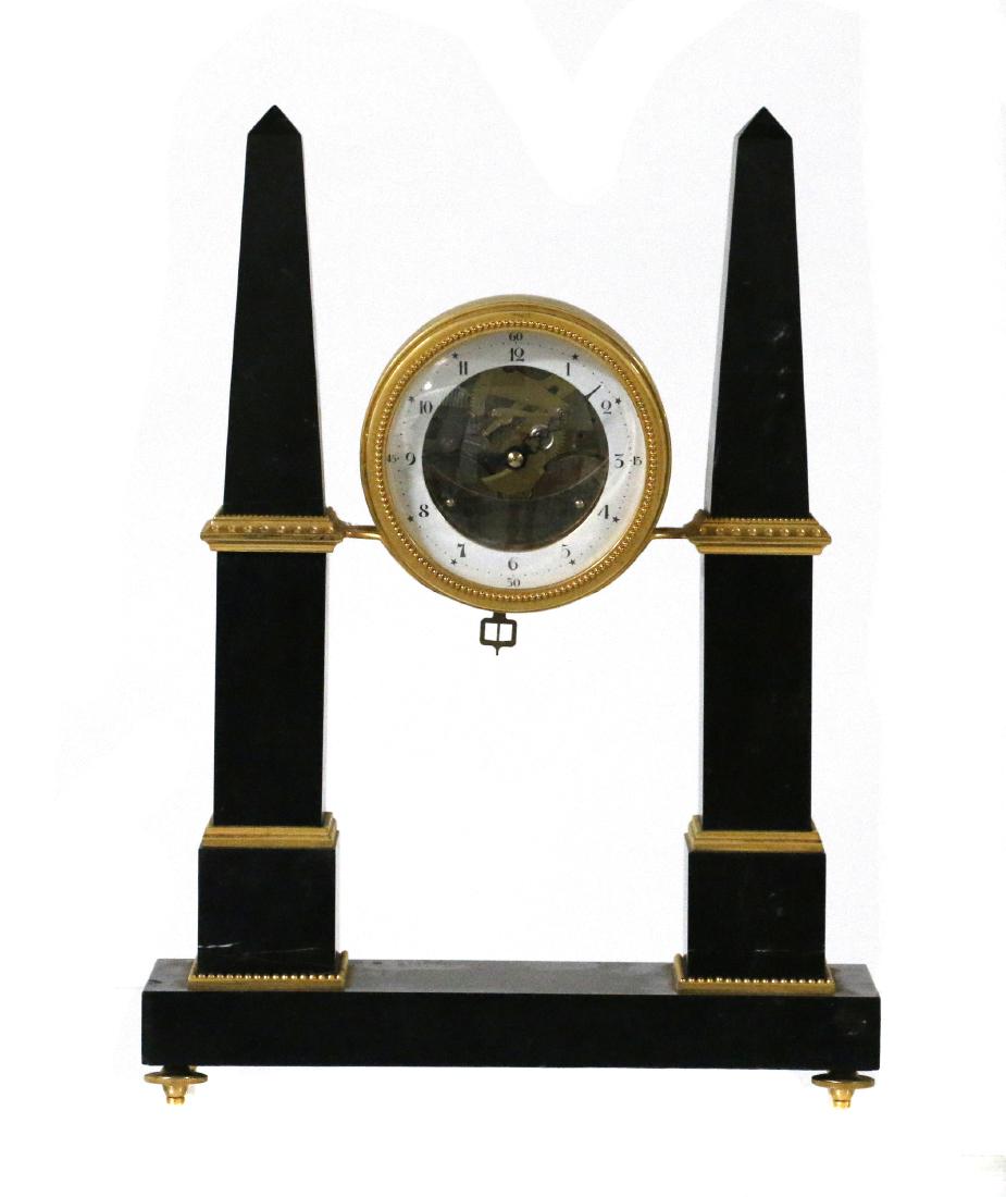 Thomas Jefferson Monticello mantle clock: The brass drum clock suspended between gilt banded black onyx obelisk 15in. (39cm) high; 12in (31cm) width