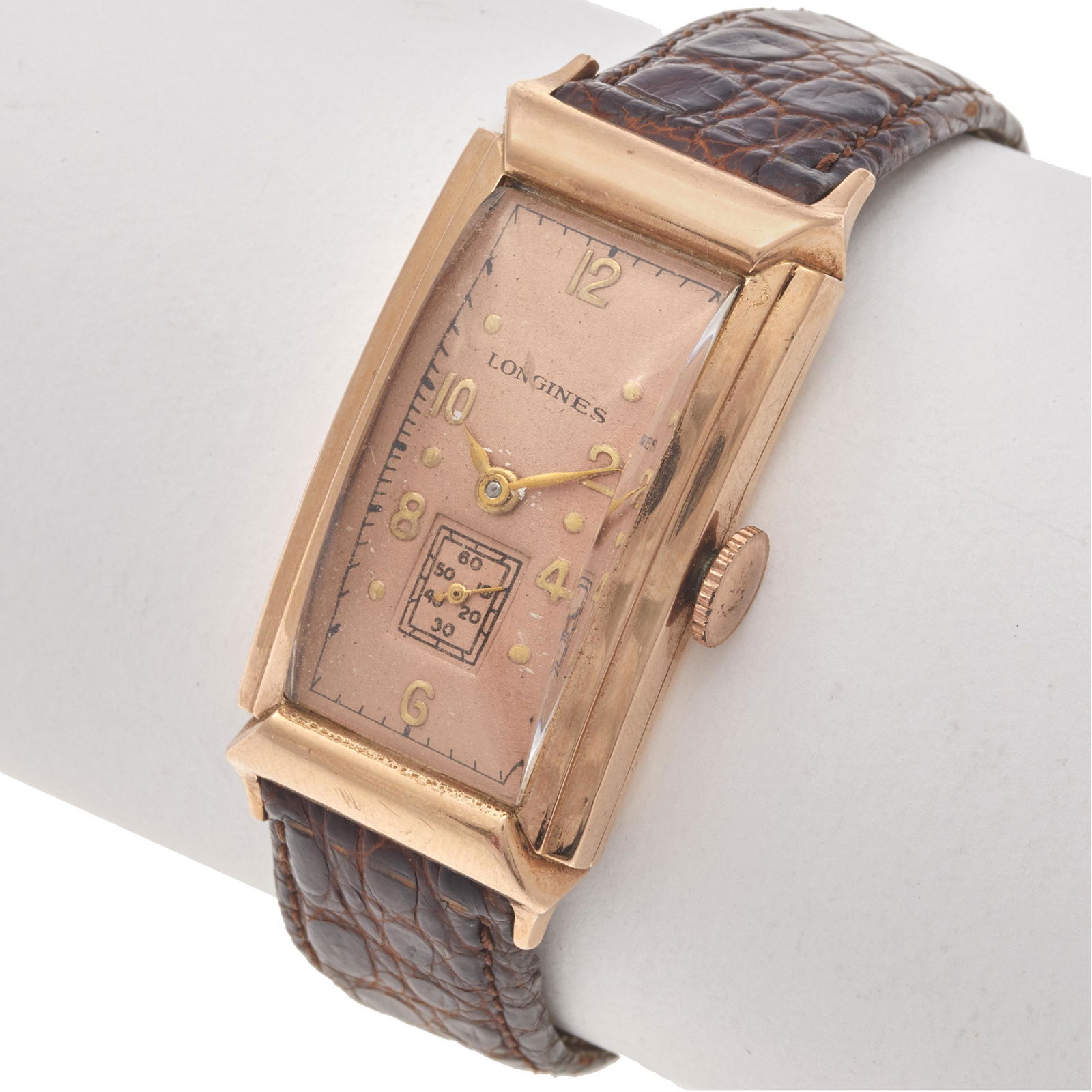 Longines Curvex 14k Rose Gold Wristwatch: DIAL: Rectangular, rose, applied gold Arabic and dot hour markers, black outer minutes track, gold dauphine hands, subsidiary dial at 6 o'clock. MOVEMENT: Mechanical, seventeen (17) jewels, unadjusted