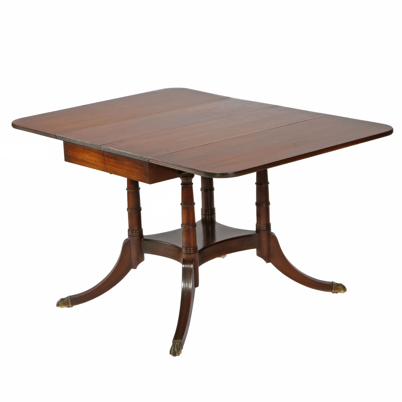 Regency Style Mahogany Dining Table: First quarter 20th century. An Exceptionally useful table, with drop leaves on each side, opening at the center to a butterfly leaf, raised on turned standards and swept legs ending in gilt paw feet.
