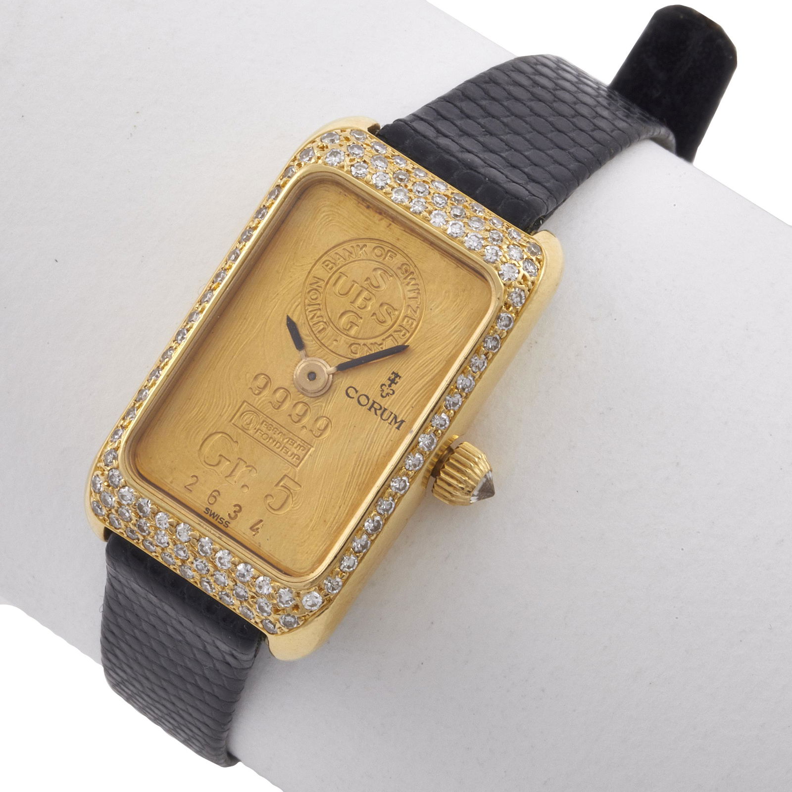 Corum Diamond, Gr. 5 Ingot, 18k Yellow Gold Wristwatch: DIAL: Rectangle, gold ingot, black baton hands, Corum, impressed "Union Bank of Switzerland" within circular "U.B.S.S.G," then "999.9 Essayeur Fondeur, Gr. 5, 2634." MOVEMENT: Mechanical (case not op
