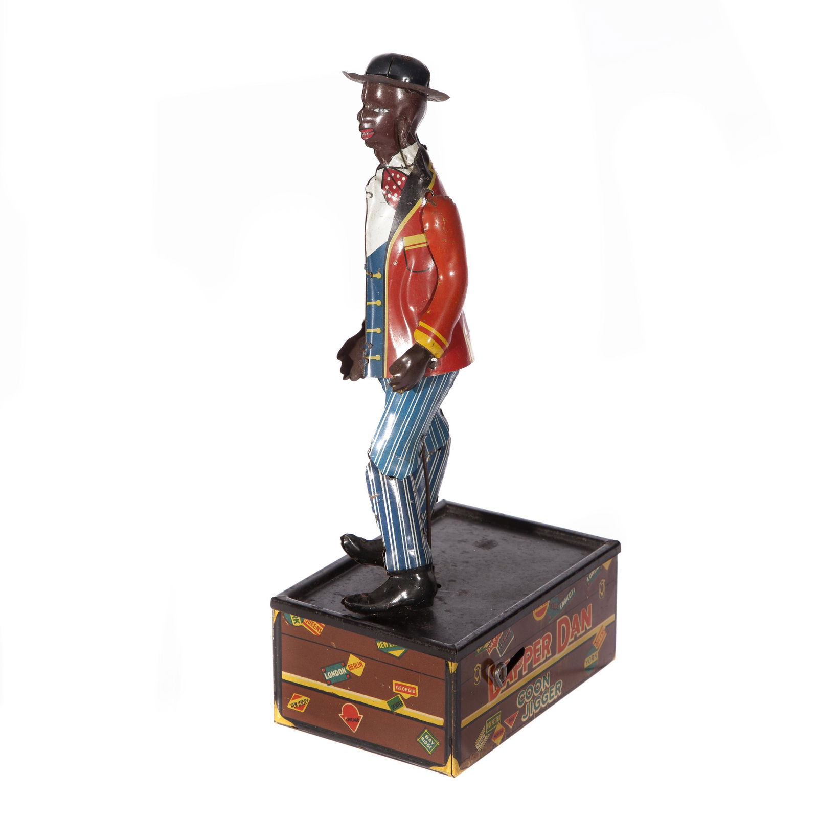Dapper Dan Wind Up Toy: 'Dapper Dan' Wind up 'Coon Jigger' figure on top of luggage chest with travel sticker motif. Measures 9 3/4in. H x 4 3/4in. W.Â item condition: Wind up works, good to very good, with some wear and