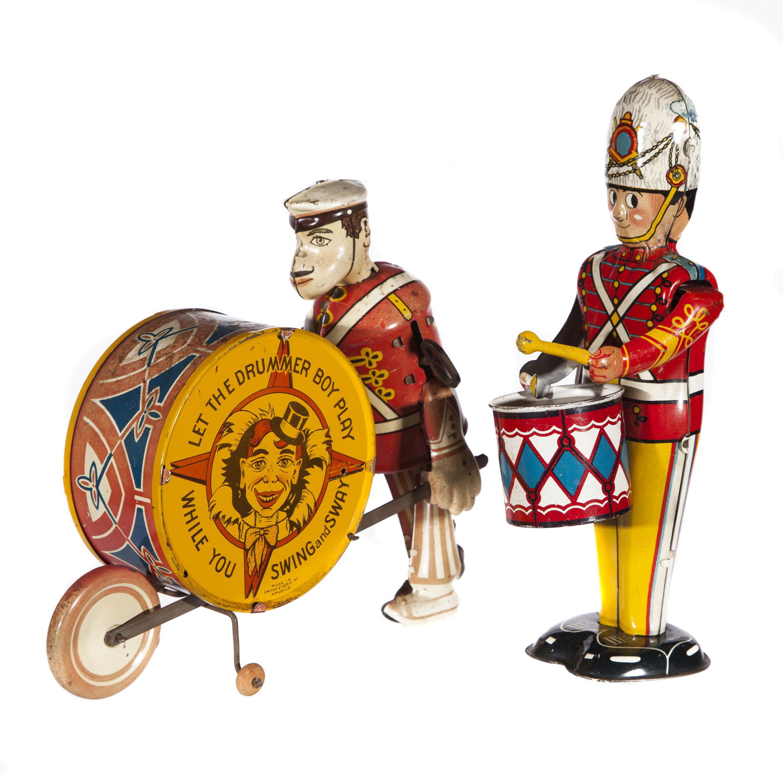 Drummer Men Toys: Two wind up drummer toys. A mustached drummer pushes a drum with as the words on it proclaim: 'Let the Drummer Boy Play' made by Louis Marx U.S.A. 9in. L x 7 1/4in. W x 3 1/2in. H. A standing soldier