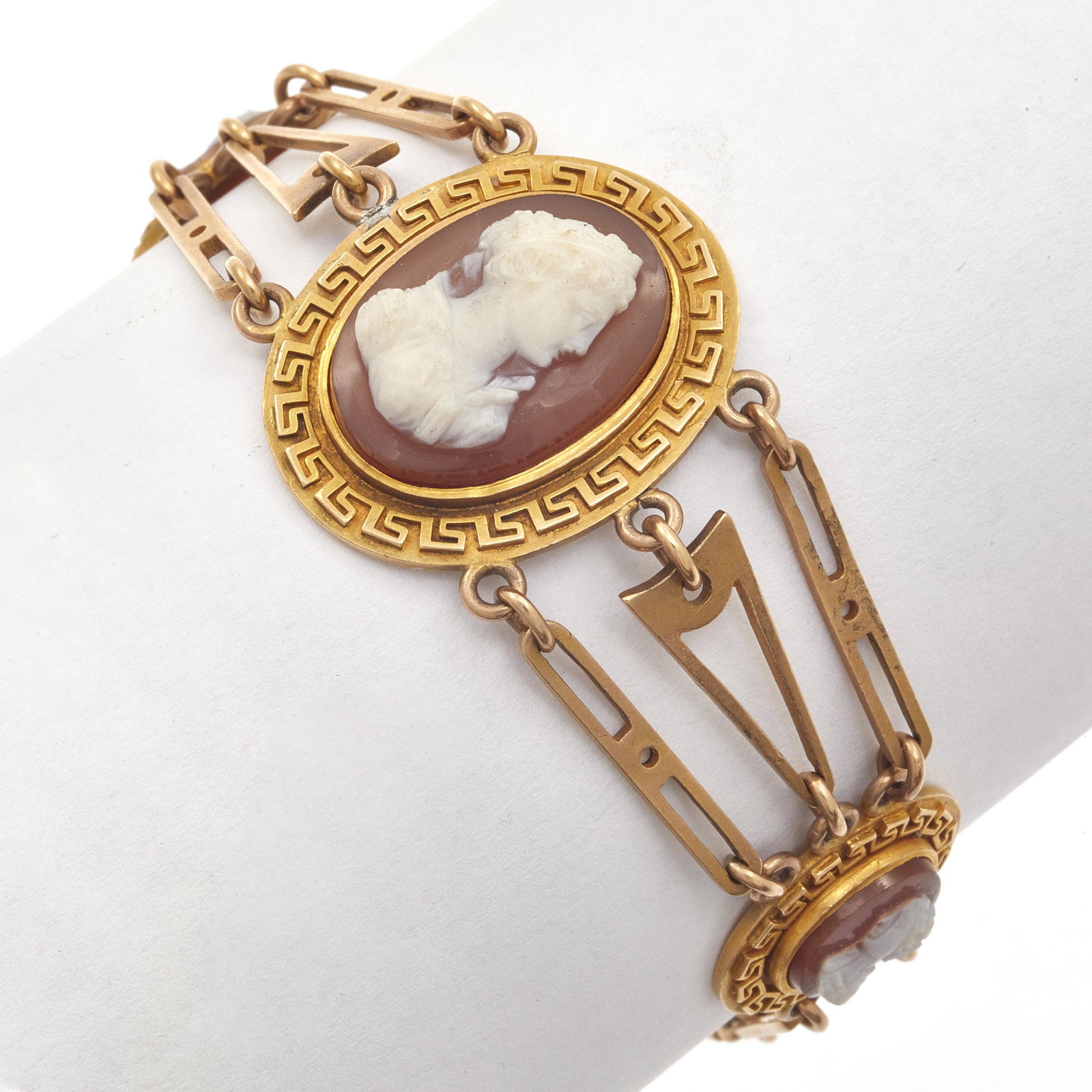 Hardstone Cameo, 14k Yellow Gold Bracelet: Featuring three oval hardstone cameos of classical beauties set in 14k yellow gold textured mountings joined by geometric-shape links, completed by a tongue-and-groove box clasp with safety chain form