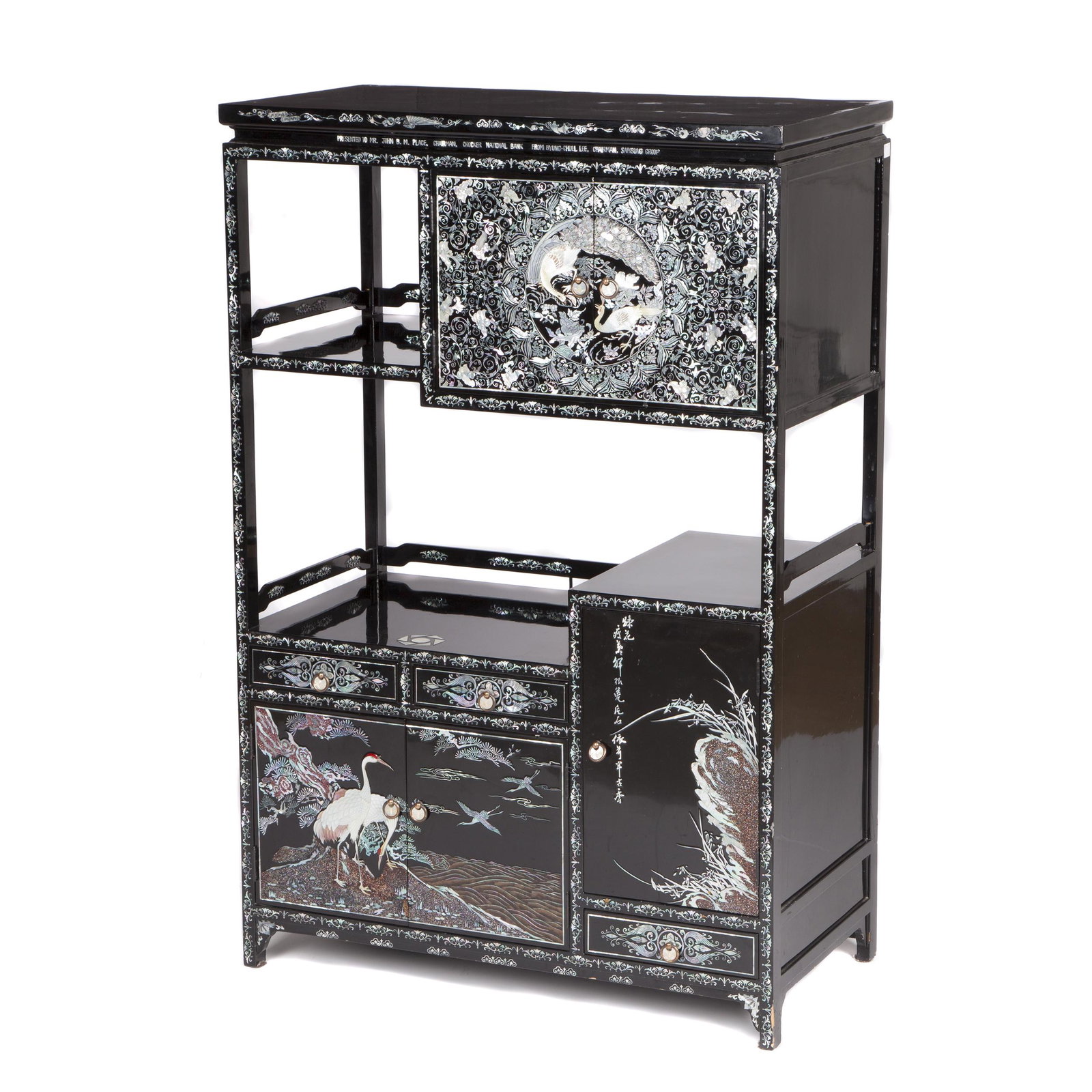 Korean Lacquered Display Cabinet, 20th Century: The black lacquered cabinet displaying finely inlaid mother-of-pearl decoration of peafowls and cranes, with inscriptions in Chinese and English characters. 43 3/4 x 29 1/4 x 14 3/4 inches Provena