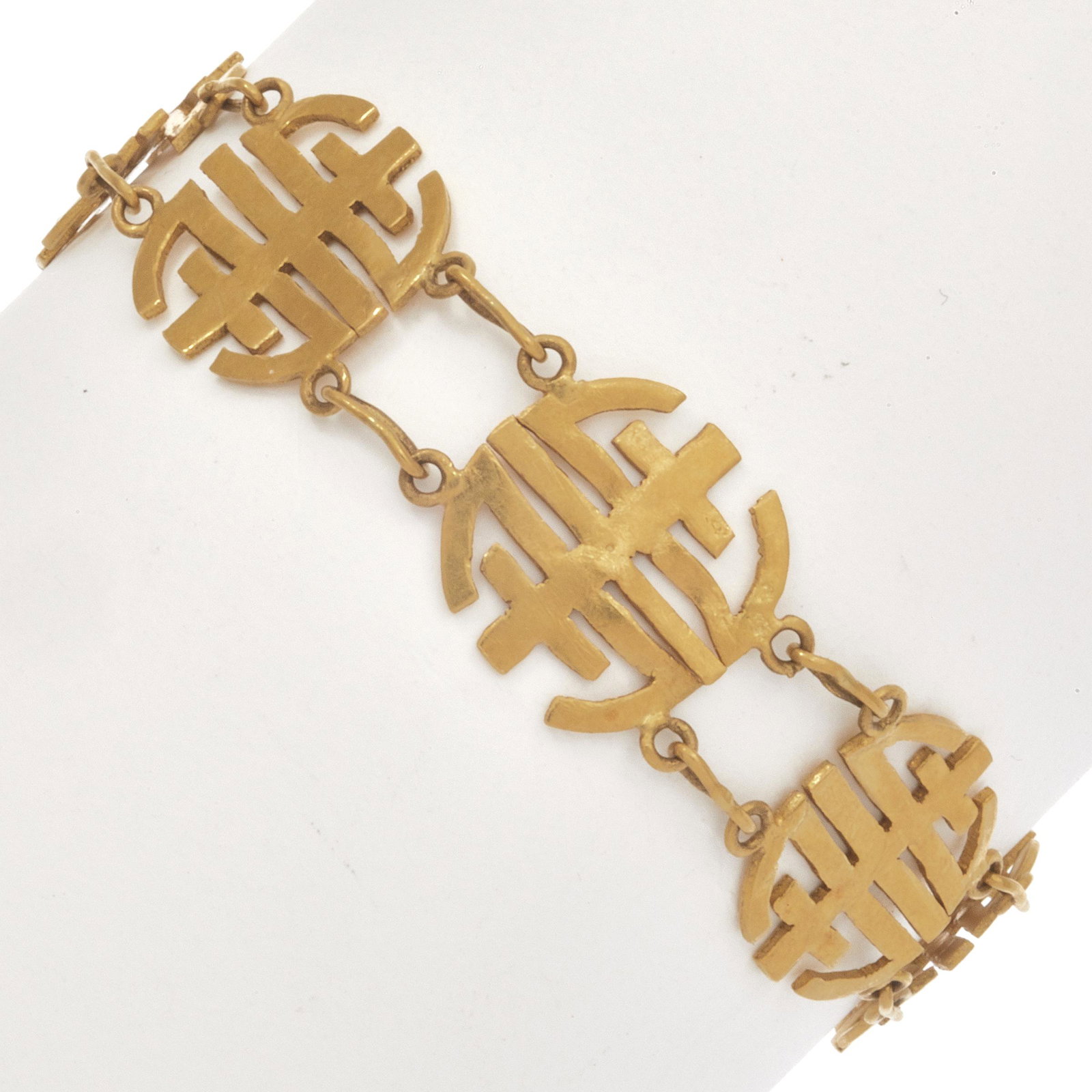 Asian 22k Yellow Gold Bracelet: The 22k yellow gold pierced calligraphy links, each measuring approximately 14.7 mm in width, completed by an "s" hook clasp forming a 7 inch bracelet. Gross weight: 15.0 grams. Item condition: some l