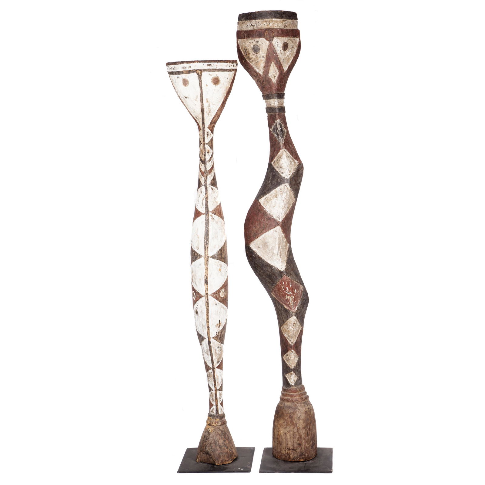 Pair of Baga Snake Sculptures: Displaying carved diamond pattern painted in brown, black and white, the neck with three grooves, circular eyes, a raised vertical strip down the center. Height: 86 and 77 inches
