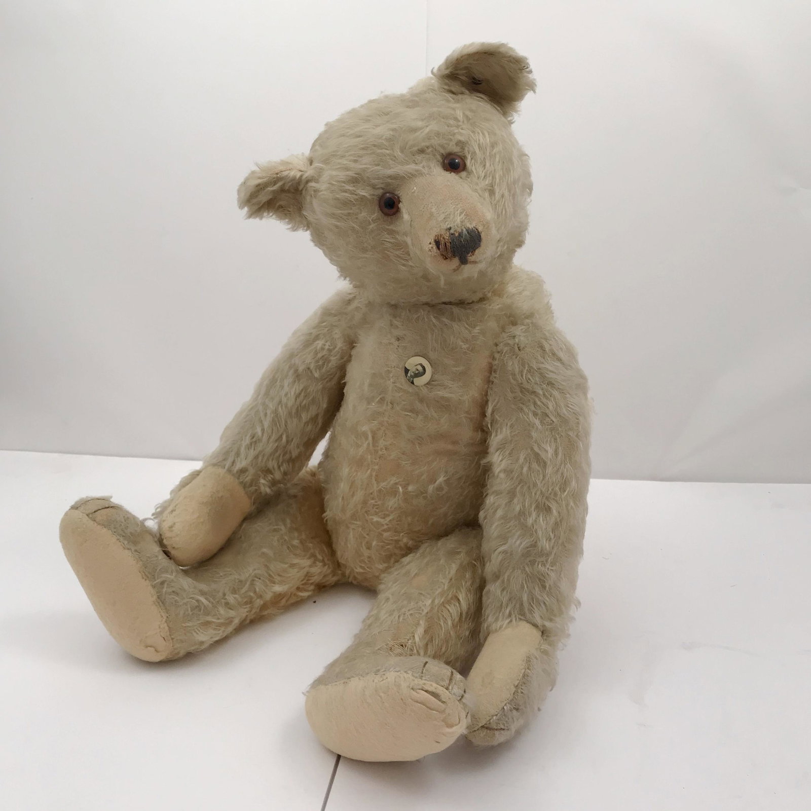 Steiff Vintage Mohair Humpback Teddy: The mohair teddy, jointed with center seam, stitched nose and glass eyes. Decorated with a Teddy Roosevelt campaign button on the chest. 22in. (56cm) l; 16in. (41cm) from seated. Condition: some wear.