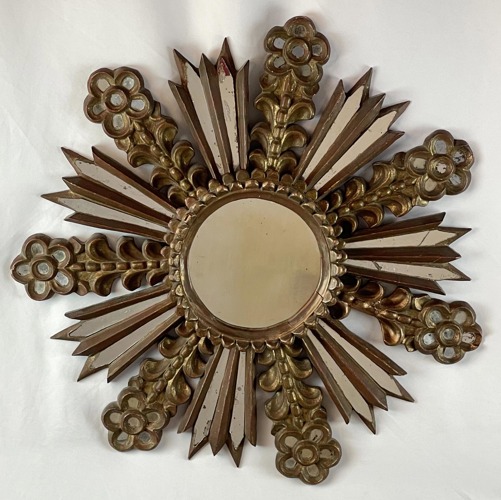 Venetian Rococo Style Giltwood Mirror: Composed of antique and later elements. The central circular plate issuing mirror slip rays and flower stalks. 25in. (63cm) d.