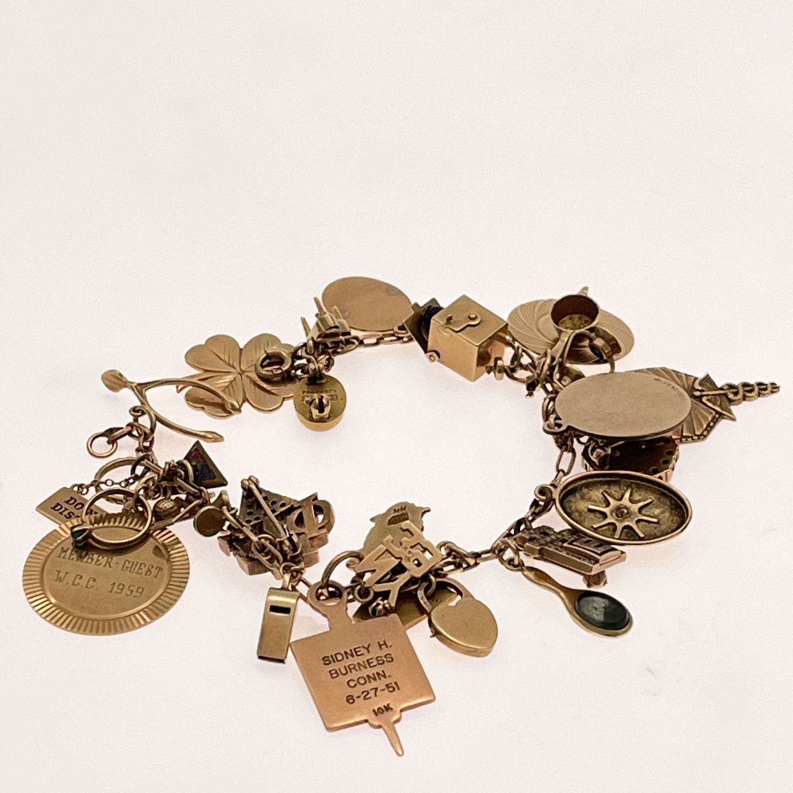 14k Yellow Gold Charm Bracelet: 14k Yellow Gold Charm Bracelet The 14k yellow gold oval links featuring twenty-eight charms, 14k includes: mirror, padlock, Green man, plaque "NY39," whistle, golf ball with tees, textured ring, ring