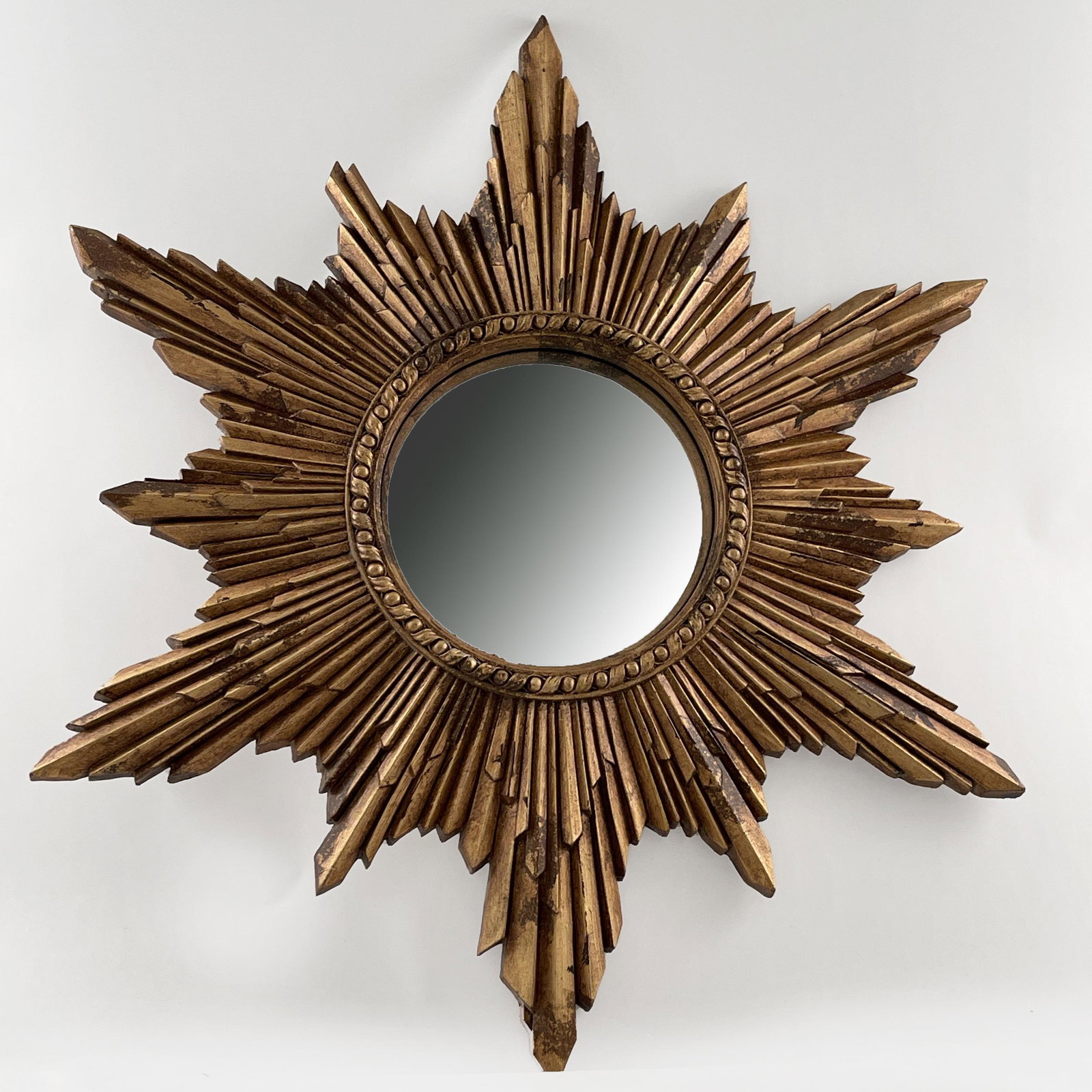 A Venetian Style Giltwood Mirror and Frame: Composed of 19th century and later elements. The fist with convex plate within a giltwood starburst frame, 24in (61cm) d. the frame with gilt mirror slip rays, 23in. (58cm)