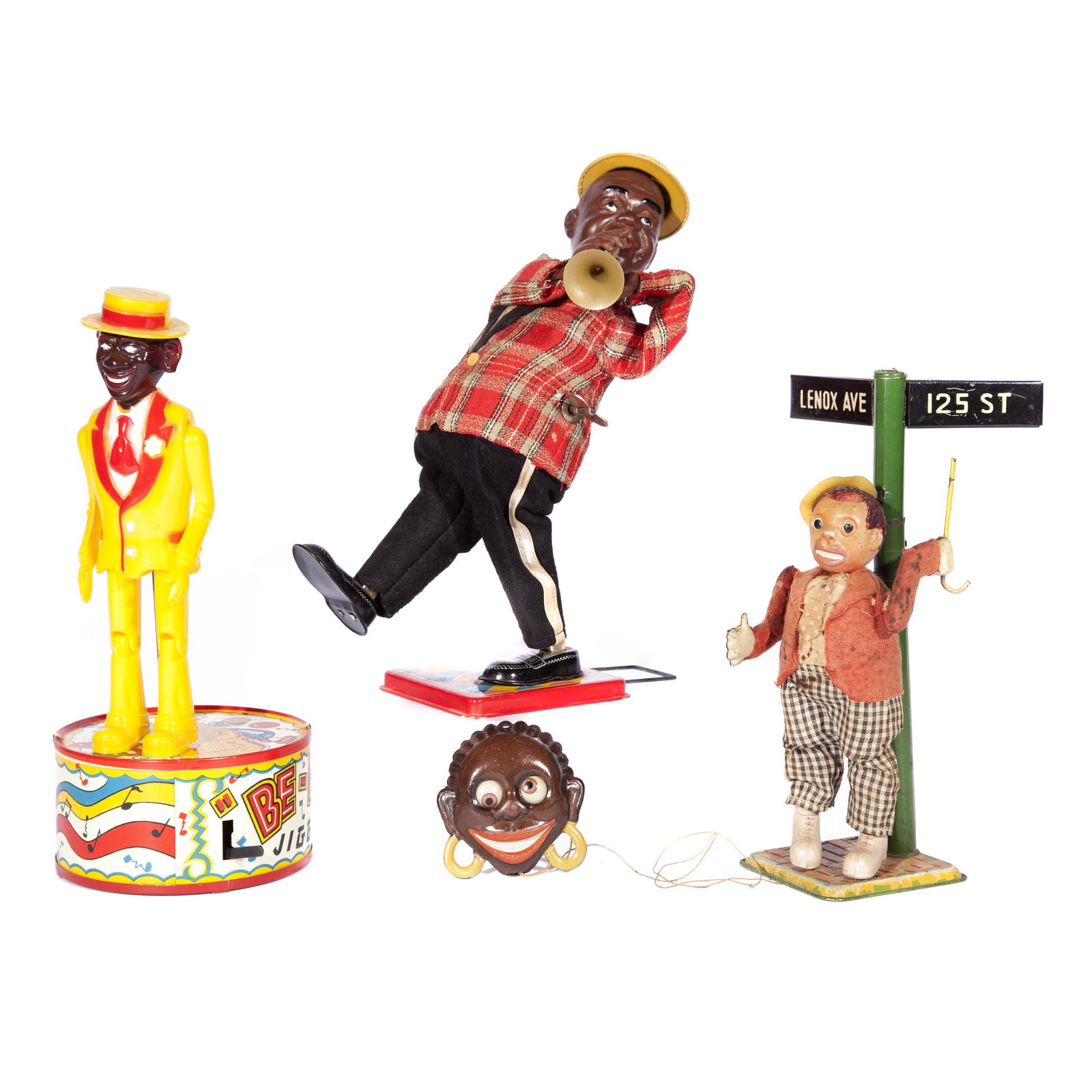 Group of Four Tin Wind Up Black Americana Toys: Various types of Black Americana toys: Lennox Ave. Jigger made in occupied Japan, Be-Bop Jigger Marx Toys, Pull toy face with string and pin, and Trumpet Player T.N. Japan that measures 10in. H x 4in.
