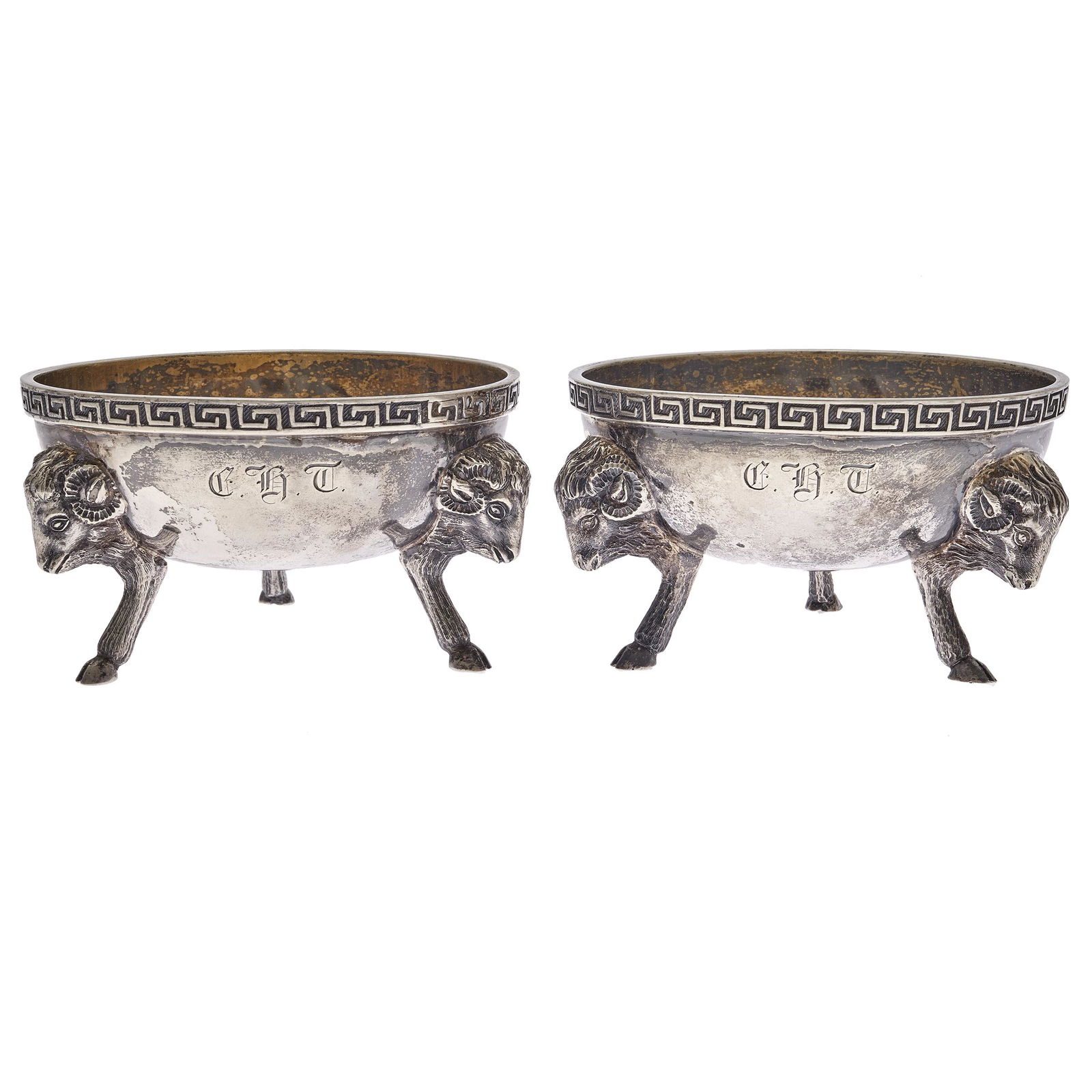 Tiffany & Co. Sterling Salts: Silver and silver gilt, Neoclassical pattern with Greek key band, raised on ram's head supports. Monogrammed 2in. (5cm) h. 3in. (7cm) d. 185.8 grams