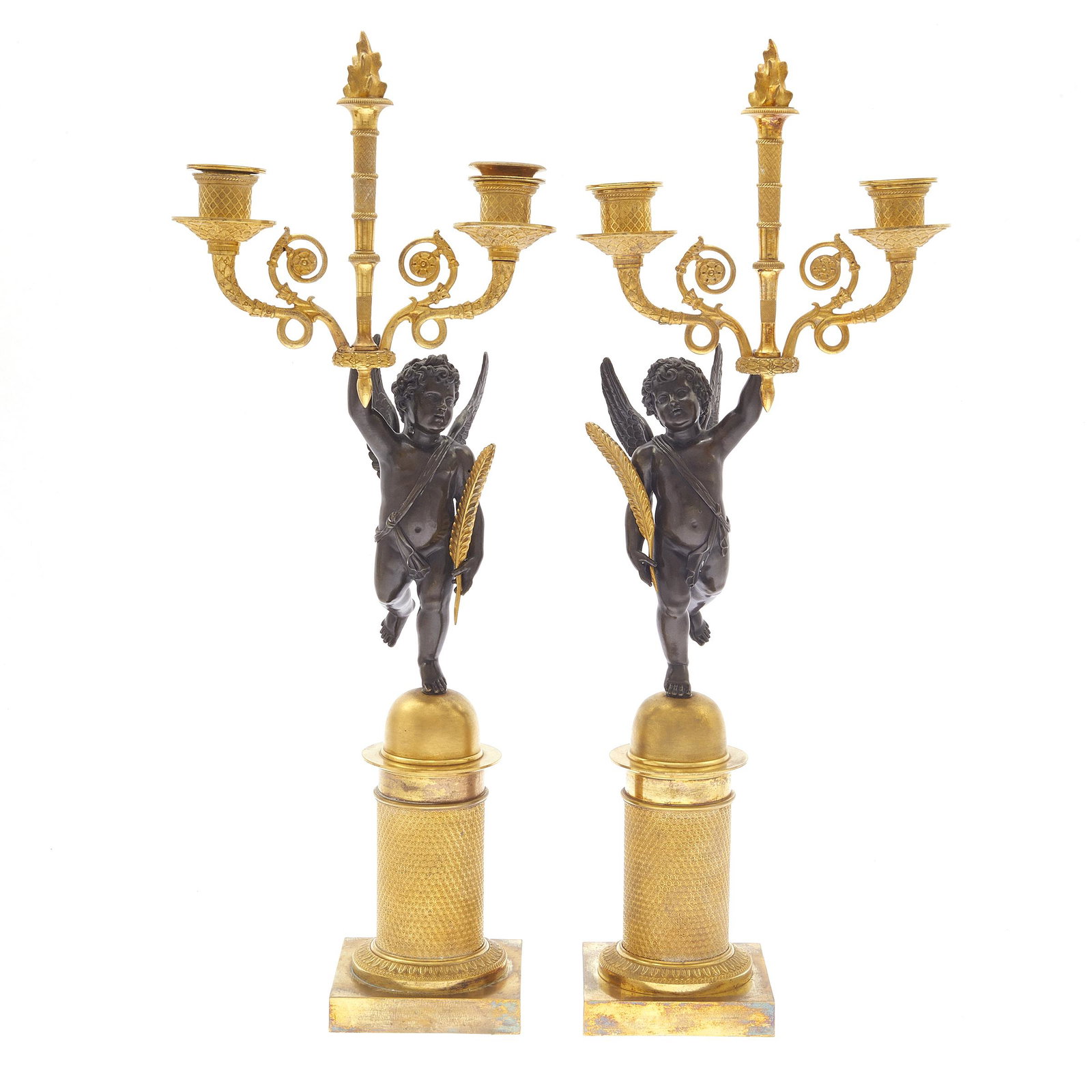 A Pair of Empire Style Bronze and Gilt Candelabra: Each in the form of a putto supporting candle cups and a central flambeau. 21in. (53cm) h.