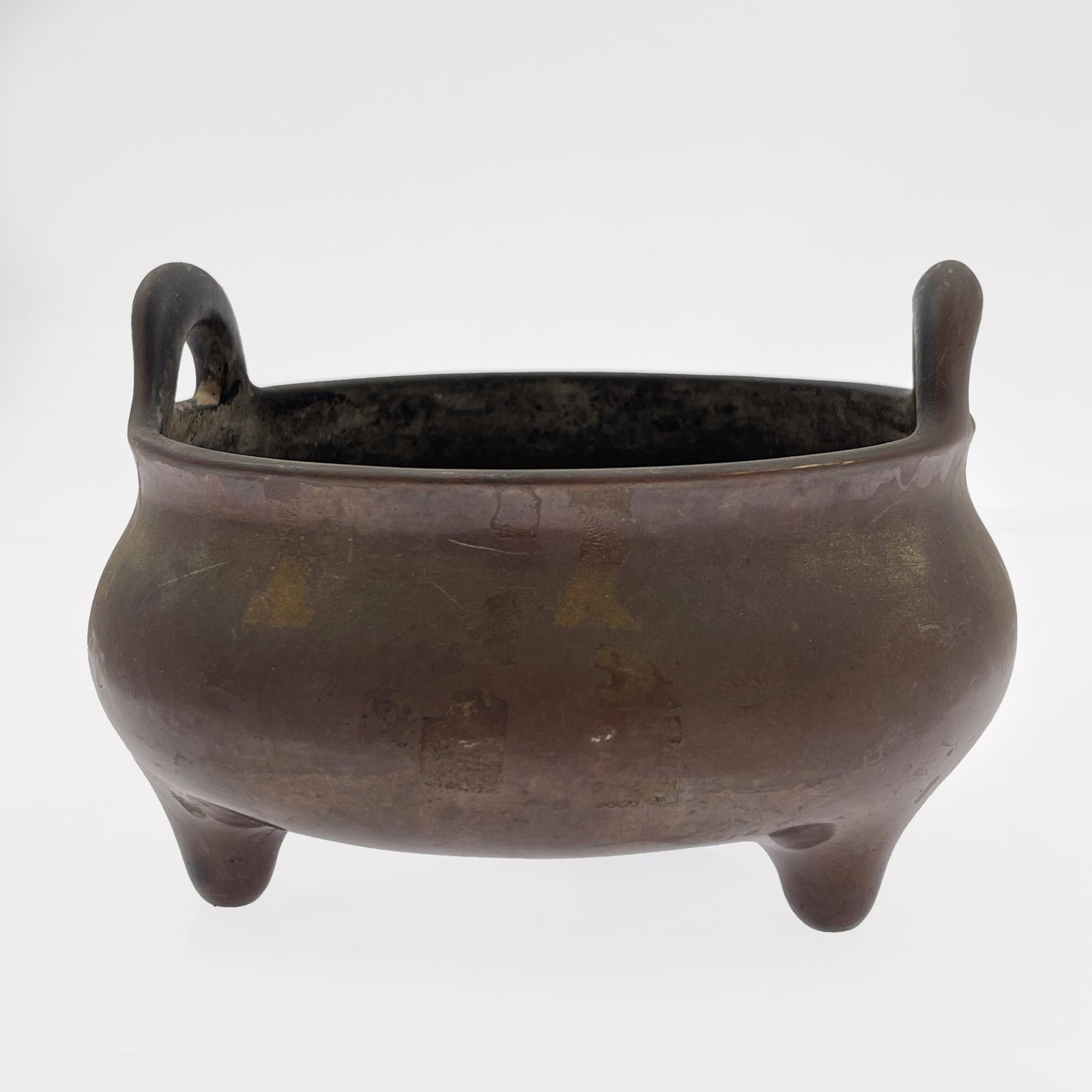 Xuan Da Bronze Incense Burner: The circular from with raised handles on tripod supports. 4 1/2in. (11cm) h. 6 1/2in. (16cm) d.