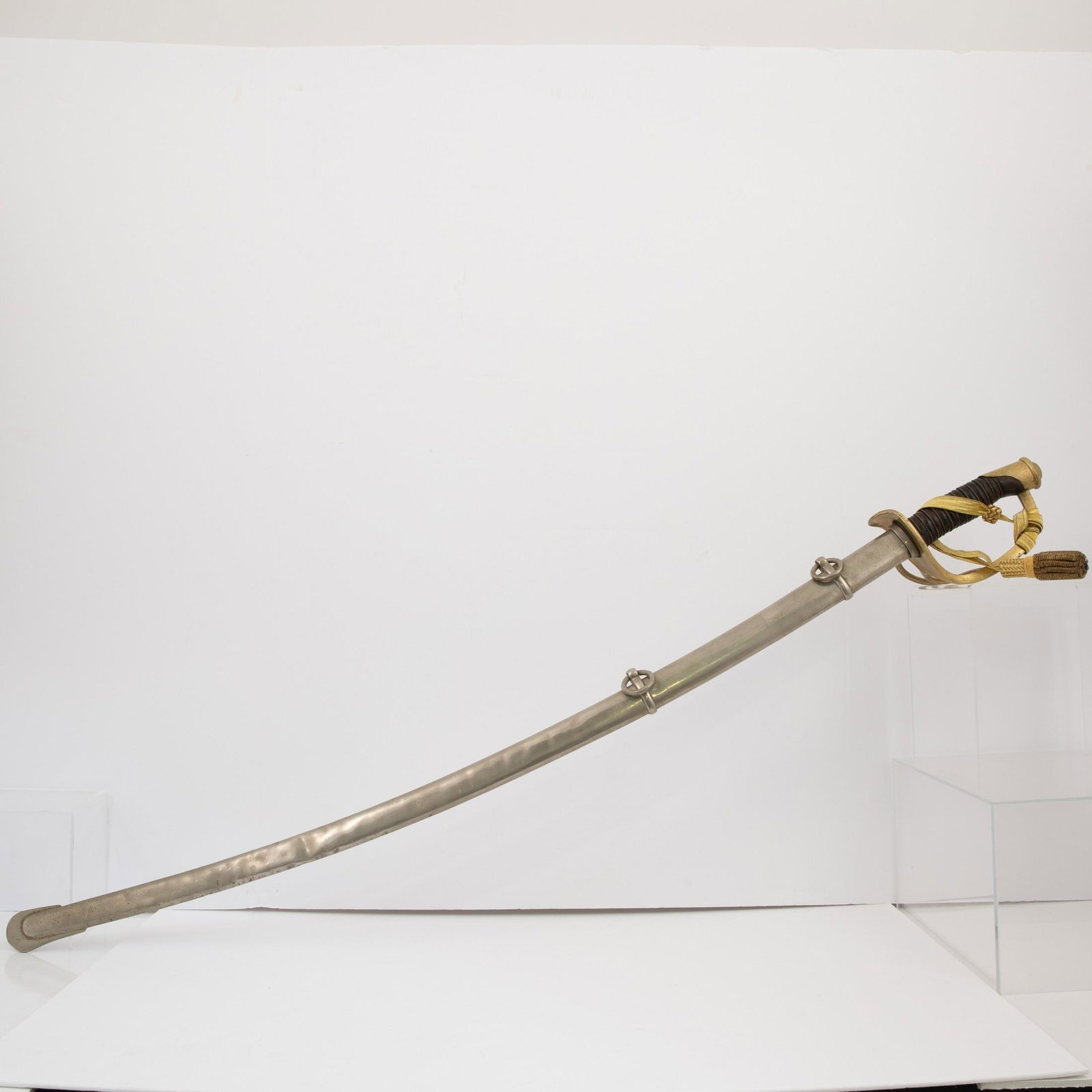 M 1860 Cavalry Saber, Curved single edged blade, wire braided grip, the ricasso stamped "U.S. / A.F.: M 1860 Cavalry SaberCurved single edged blade, wire braided grip, the ricasso stamped "U.S. / A.F. / 1864". With original steel scabbard. Measures 42" long overall, blade 34 1/2" long. In Very Good co