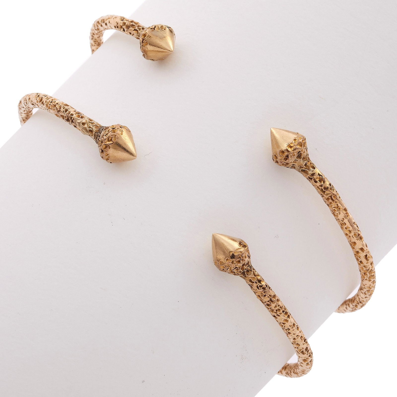 Pair of 10k Yellow Gold Cuff Bracelets: Pair of 10k Yellow Gold Cuff Bracelets The matched 10k yellow gold, textured cuff bracelets terminating to minaret finials, measuring approximately 2.5 mm in width, with a flexible inside circumferenc