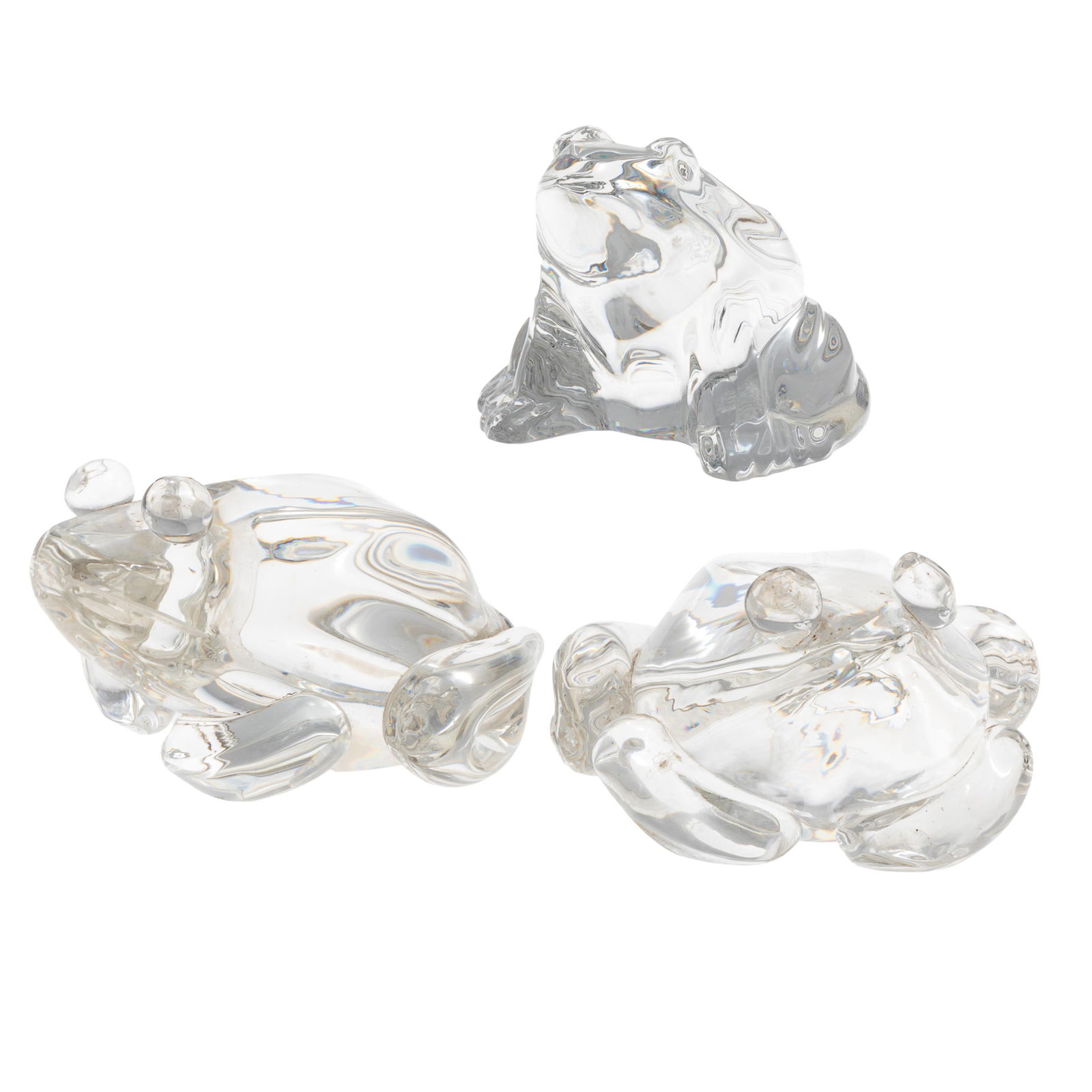 Steuben and Baccarat Glass Frogs: Steuben and Baccarat Glass FrogsTwo Steuben and one Baccarat clear glass frogs, all in a crouching posture.3in (8cm) h.4in (11cm) l.