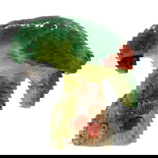 Herend Figure of an Amazon Parrot: Herend Figure of an Amazon ParrotThe bright eyed figure, green glazed with orange at the trailing edge of it's wings depicted glancing down at the ripe fruit it is perched upon.6in (15cm) h. 7in (18cm