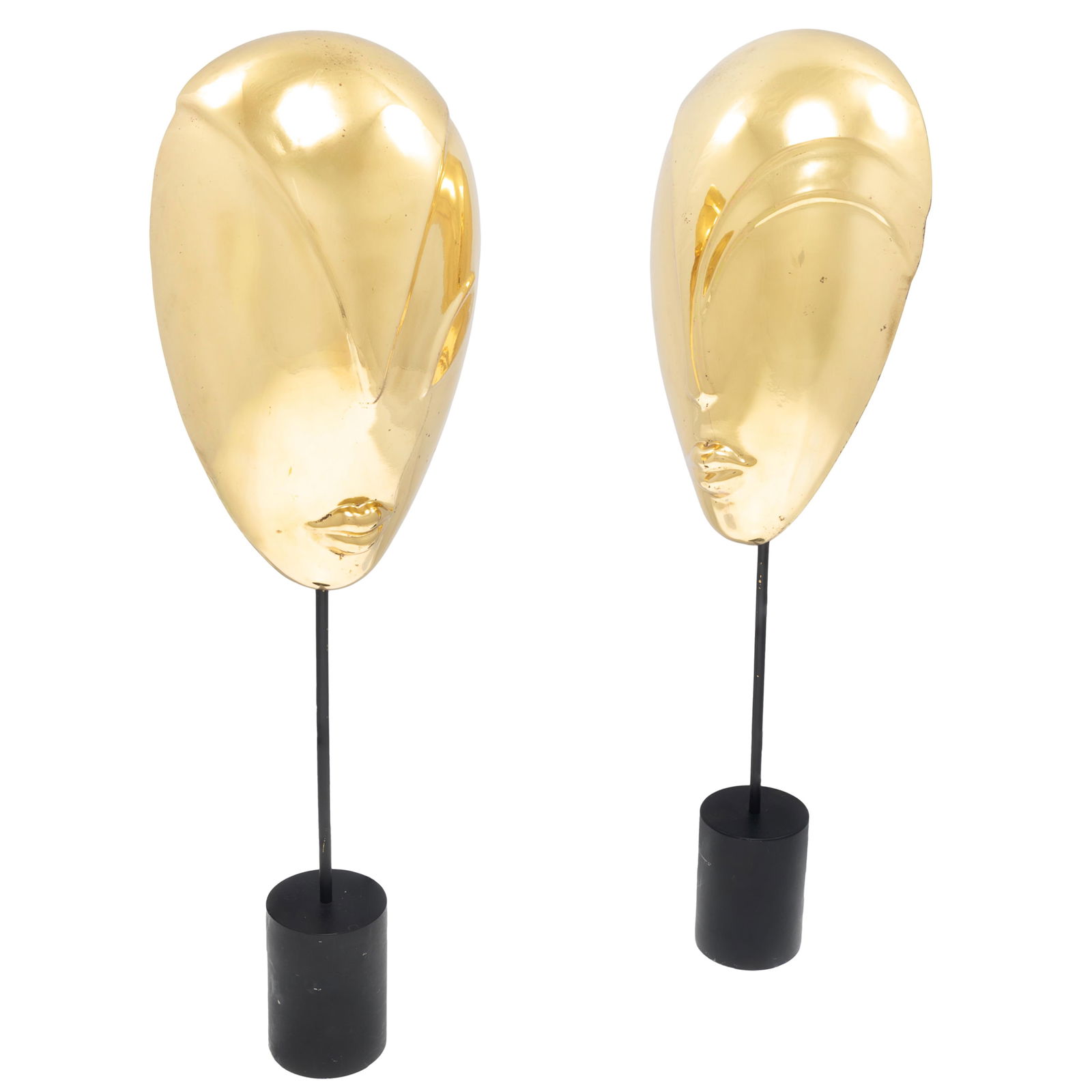 A Pair of Art Deco Style Venetian Masks: A Pair of Art Deco Style Venetian MasksEach of Art Deco design, the gilt metal masks with streamlined features presented on ebonized bases.21in (54cm) h. diameter at base 3 1/2in (9cm)Sticker on base