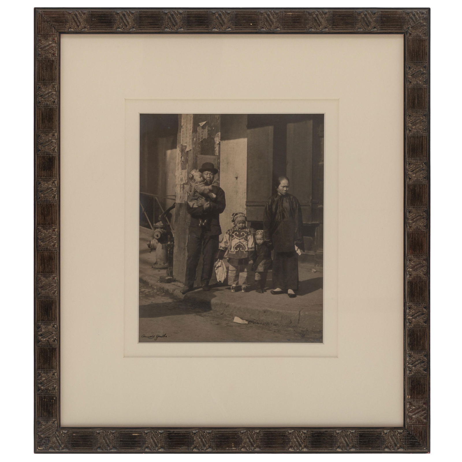Arnold Genthe (German, 1869-1942).: Arnold Genthe (German, 1869-1942). Waiting for the Cable Car, Chinatown, San Francisco, circa 1904 Warm toned gelatin silver print, signed in ink on the image, framed. 9 x 7 1/2 in. (23 x 19cm) 16