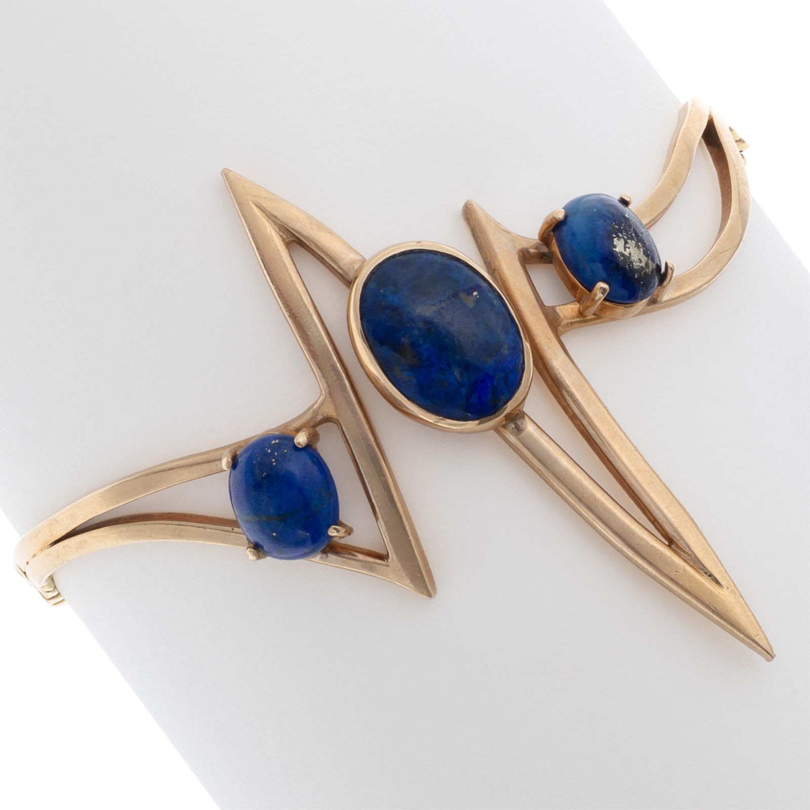 Modernist Lapis Lazuli, 14k Yellow Gold Bracelet: Modernist Lapis Lazuli, 14k Yellow Gold Bracelet Featuring three oval-cut lapis lazuli cabochons measuring from approximately 12.0 x 8.0 mm to 8.0 x 6.0 mm, set in a 14k yellow gold, geometric