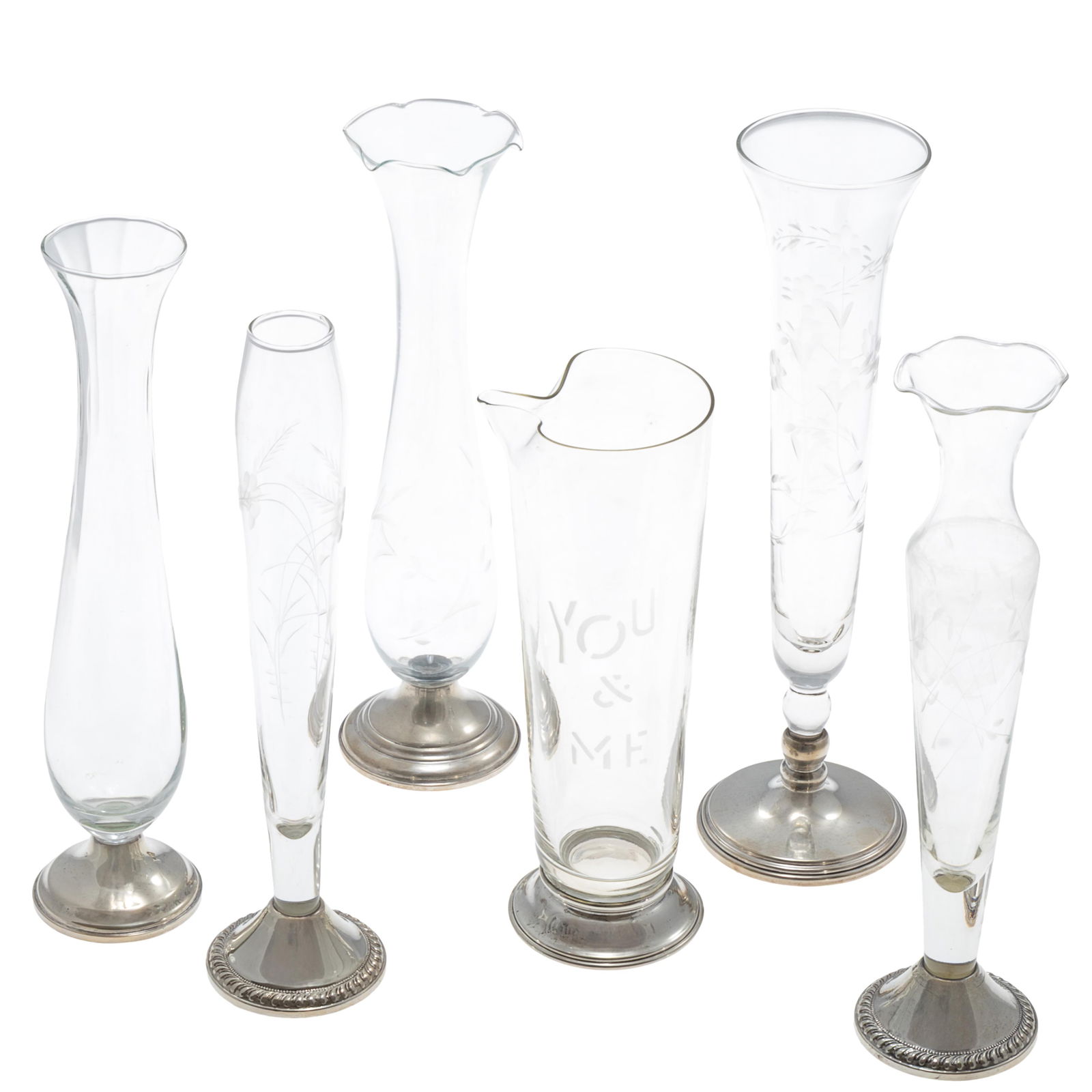 Mid Century Glass Vases and a Pitcher: Mid Century Glass Vases and a PitcherA Collection of five tall clear glass vases, floral incised with sterling bases 10-11in. With a cocktail pitcher incised 'you and me' 8 1/4inStamped on base: Sterl