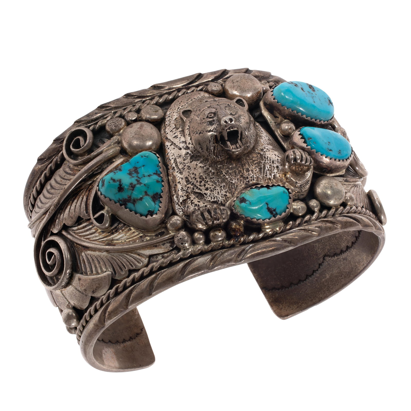 Navajo Turquoise, Sterling Silver Cuff Bracelet: Navajo Turquoise, Sterling Silver Cuff Bracelet Designed with a bear motif, highlighted by four turquoise cabochons, applied feathers, scrolls, rope work, silver spheres, and stamp work, set in a ster