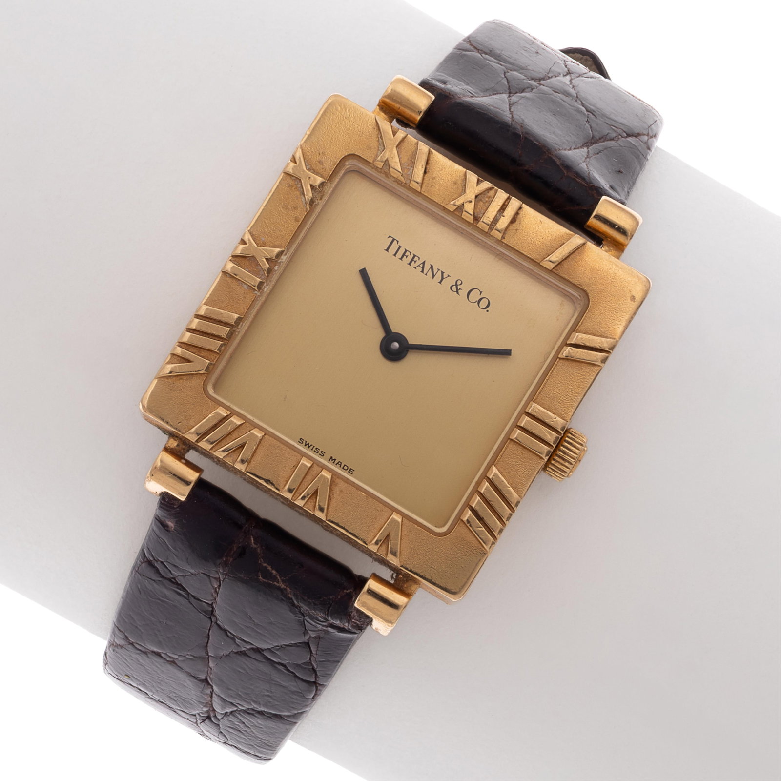 Tiffany & Co. 18k Yellow Gold 'Atlas' Watch: Tiffany & Co. 18k Yellow Gold 'Atlas' Watch DIAL: Square, champagne, Roman numeral hour markers on bezel, black baton hands, Tiffany & Co., Swiss Made. MOVEMENT: Quartz, six (6) jewels. CASE: Square, 