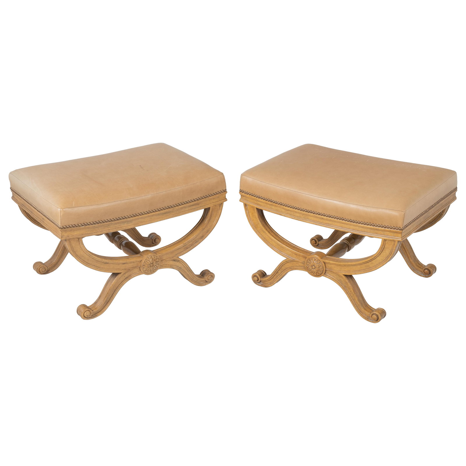 Pair of Michael Taylor d'Orsay Ottomans: Pair of Michael Taylor d'Orsay Ottomans Each with a nail head trimmed leather upholstered seat raised on Neoclassical curved supports. Joined by a floral boss Bearing plaque; Michael Taylor Design, Sa