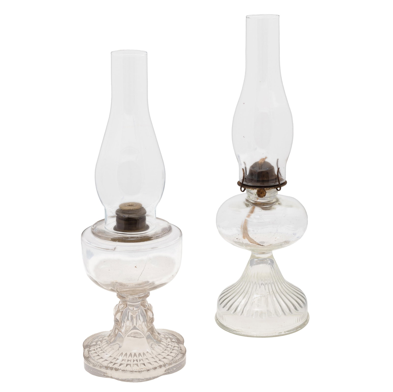Two Glass Oil Lamps: Two Glass Oil Lamps Late 19th century Pressed glass, with associated chimneys 18 1/2in and 19 1/2in Condition: One missing fitting for shade