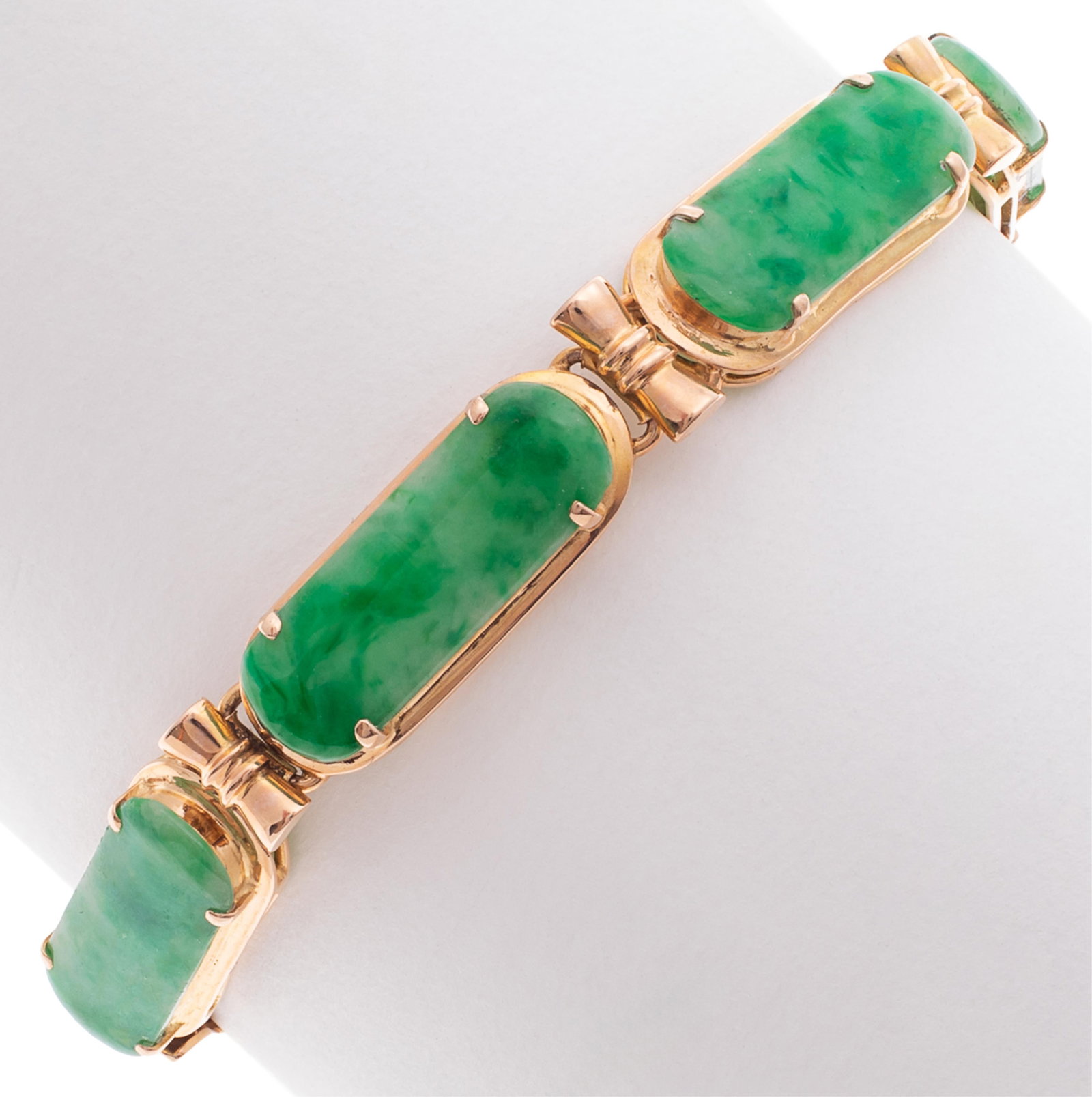 Jade, 18k Rose Gold Bracelet: Jade, 18k Rose Gold Bracelet Featuring four oval-shaped jade cabochons, each measuring approximately 18.0 x 6.8 mm, set in an articulated, 18k rose gold mounting completed by a tongue-and-groove