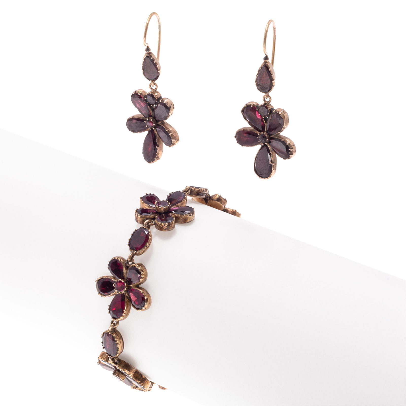 Georgian Garnet, Gold Bracelet and Pair of Earrings: Georgian Garnet, Gold Bracelet and Pair of Earrings Designed as a series flowers, composed of pear-shape and round-cut garnets interspaced by oval-cut garnets, set in an articulated rose gold mounting