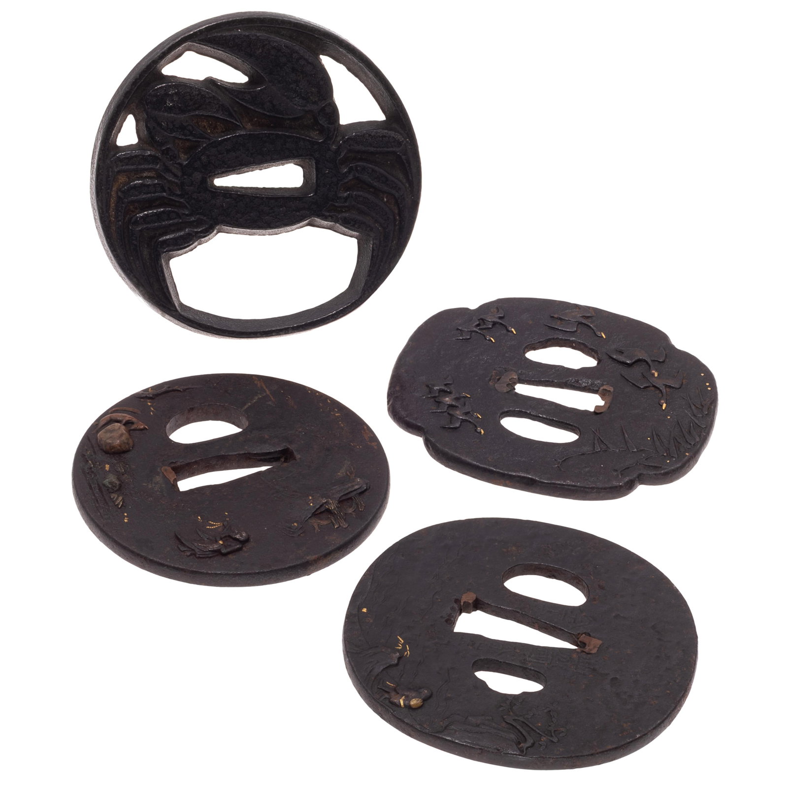 Four Japanese Iron Tsuba: Four Japanese Iron Tsuba Four iron tsuba with various forms and motifs, including a rounded tsuba, incised landscape, water lines and characters around the center opening and a gilt "82"; a Mokko-form