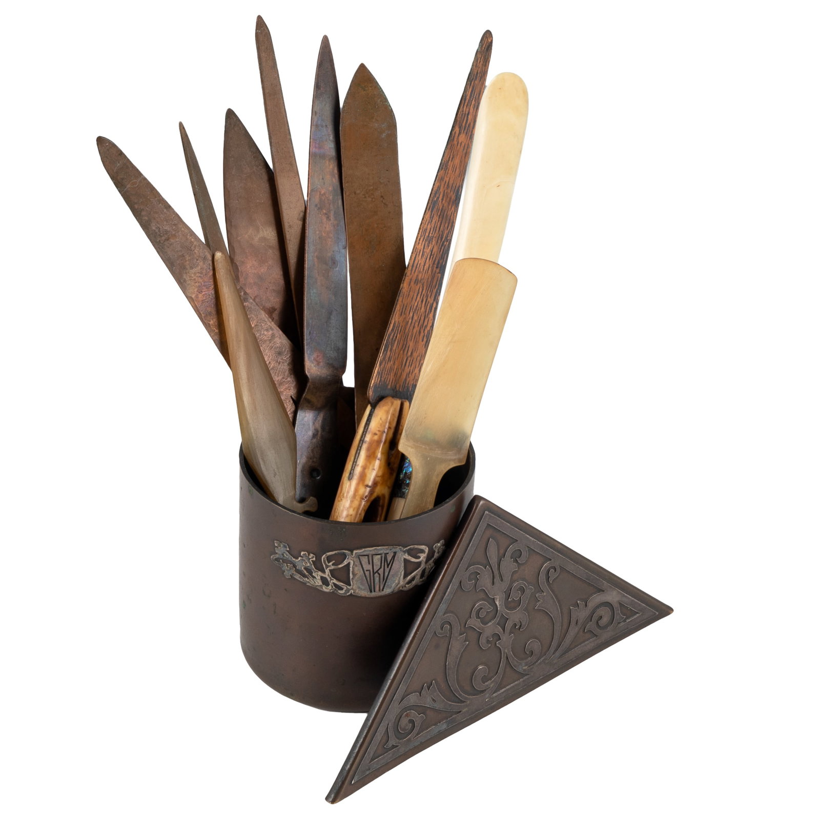 Arts & Crafts Desk Accessories: Arts & Crafts Desk Accessories Heintz Art Metal Shop silver on bronze cup, silver monogrammed 'GRM', containing 10 Arts & Crafts era letter openers including hammered copper, celluloid, bone, etc.;