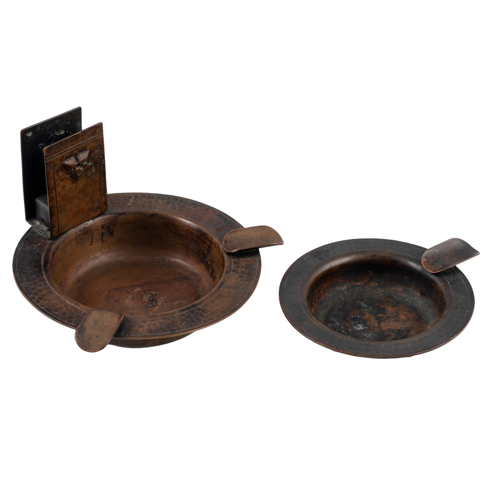 Old Mission Kopper Kraft Ashtrays: Old Mission Kopper Kraft Ashtrays Two Old Mission Kopper Kraft hammered copper ashtrays. One with two cigarette / cigar holders and affixed matchbook holder with applied leaf decoration; together