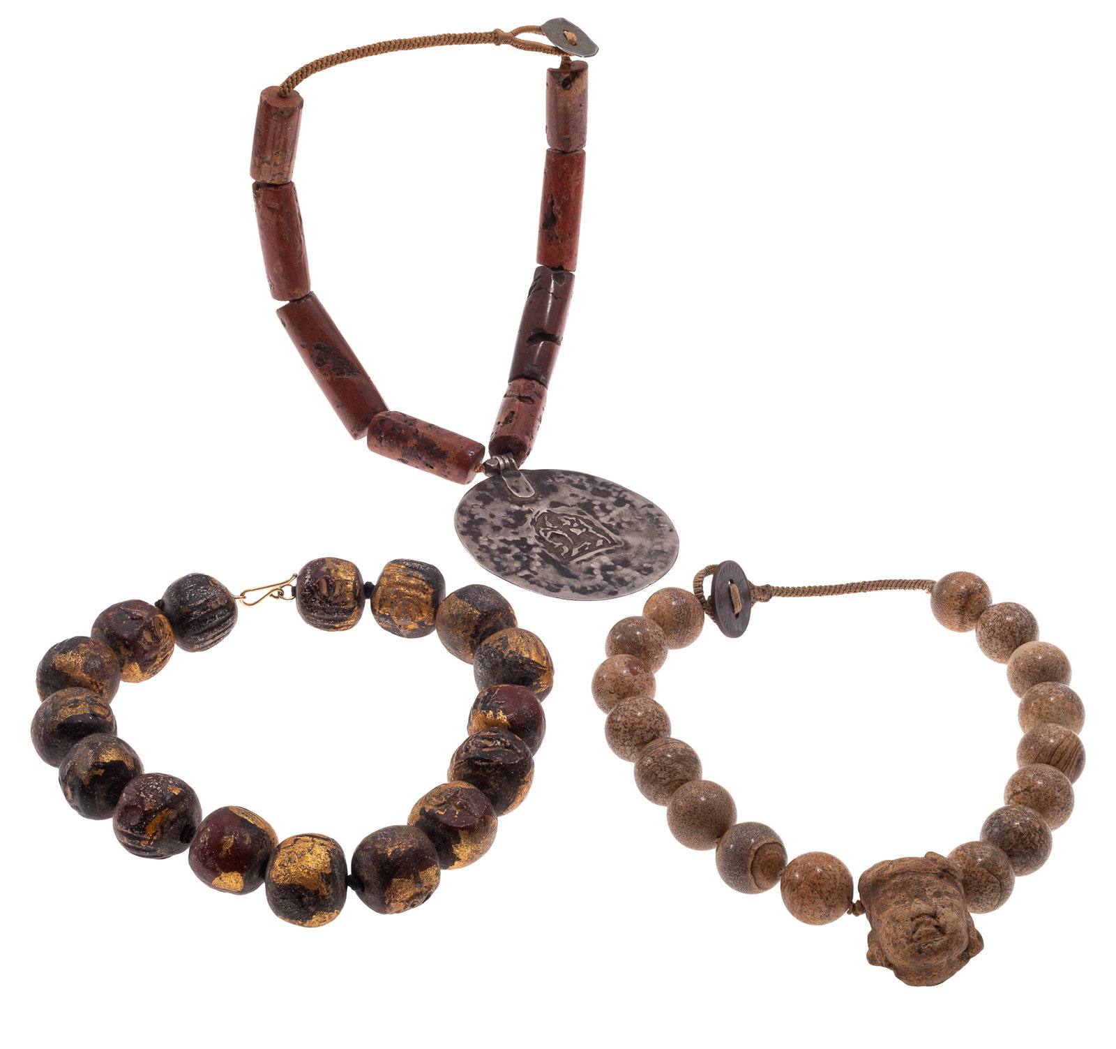 Collection of Three Ethnographic Necklaces: Collection of Three Ethnographic Necklaces Including one necklace composed of tubular bauxite beads suspending a silver Indian medallion depicting a rider on a horse, completed by a silver metal disc 