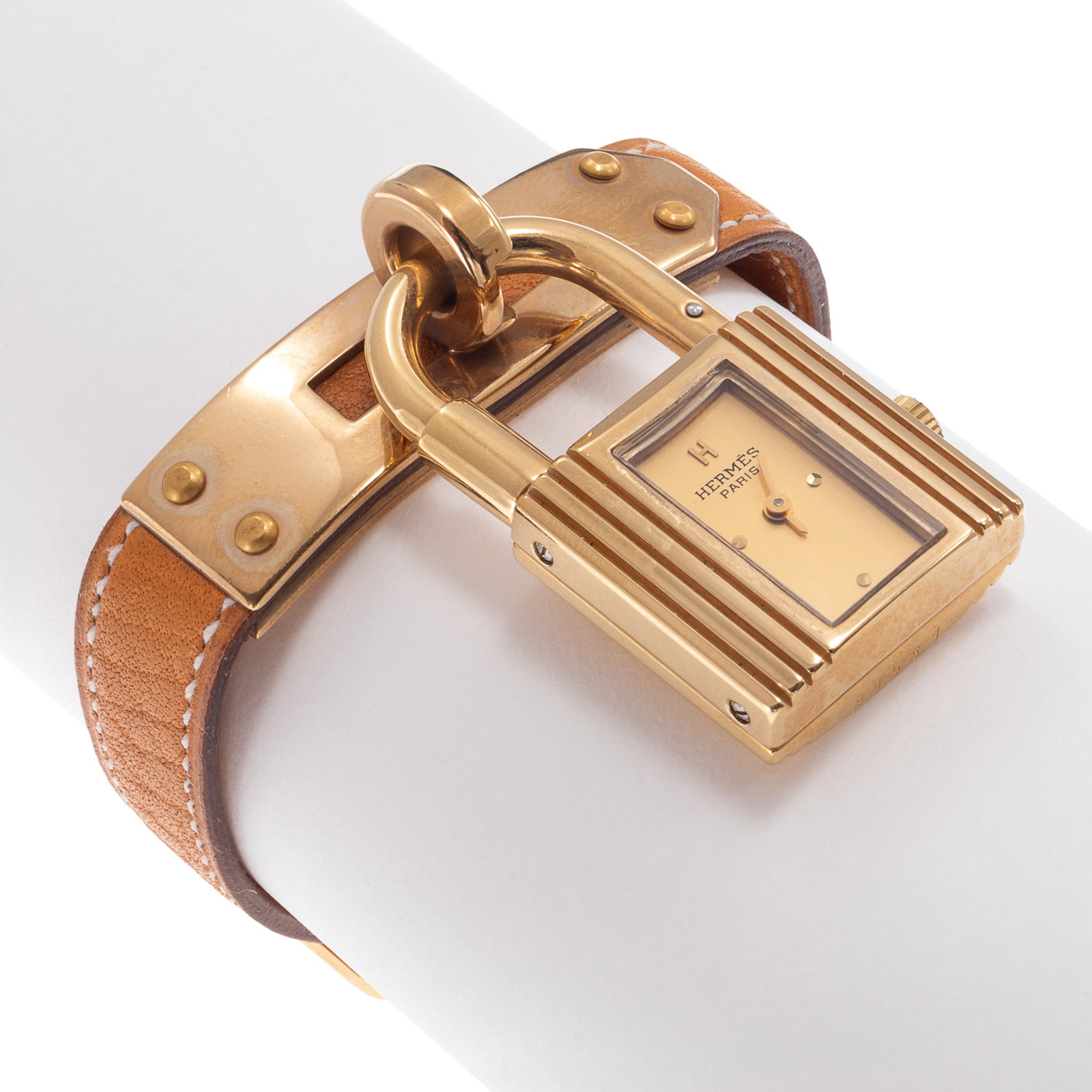 Hermes, Ladies Gold-Plated Kelly Watch: Hermes, Ladies Gold-Plated Kelly Watch DIAL: Rectangle, gold, applied dot and 'H' hour markers, baton hands, Hermes, Paris, Swiss Made. MOVEMENT: Quartz. CASE: Gold-Plated, designed as a lock, 38.0 x