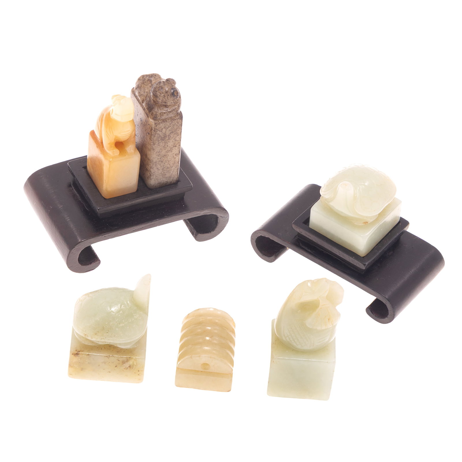 Six Chinese Carved Jade and Hardstone Seals: Six Chinese Carved Jade and Hardstone Seals Comprising six seals of various colors and forms, including pale green, russet-brown, and honey toned examples. Five are surmounted by carved animal or