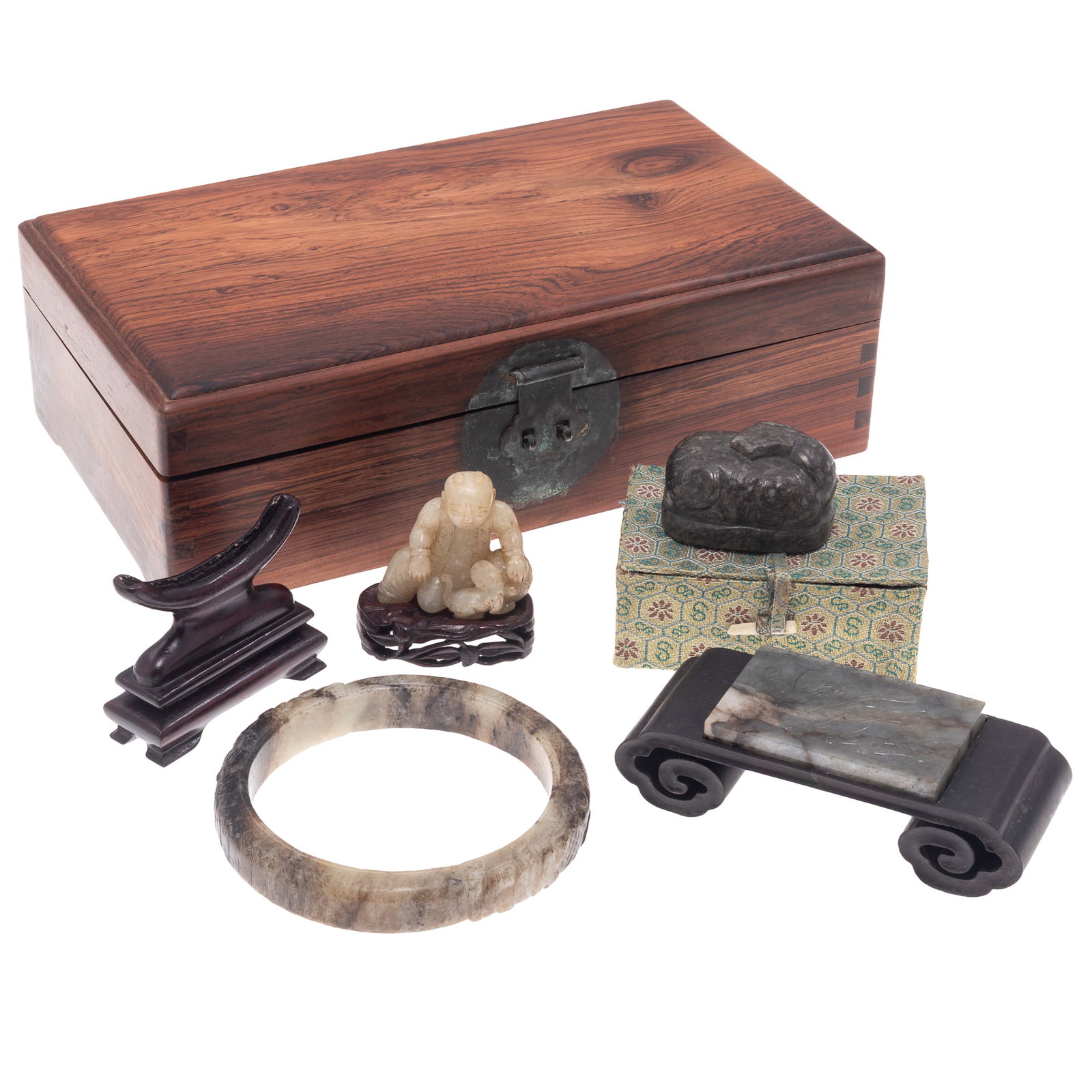 Four Jade Articles: Four Jade Articles Comprising: A pale celadon jade carving a a seated figure with a dog, raised on a fitted carved wood stand; a dark gray jade oval form seal decorated with recumbent mythical beast, 
