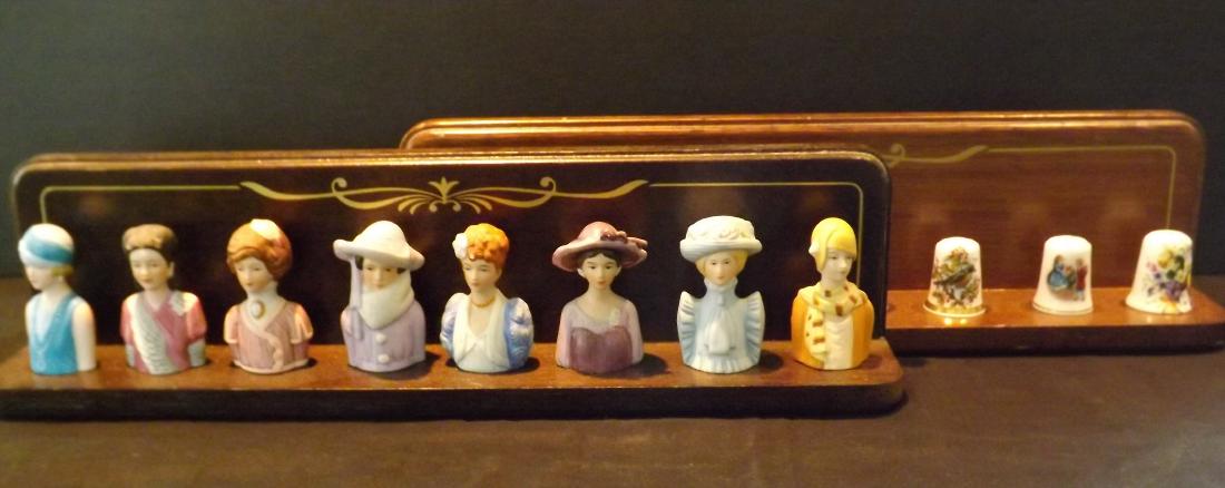 2 SETS OF COLLECTIBLE THIMBLES: 2 SETS OF COLLECTIBLE THIMBLES - 8 VARIOUS THIMBLES; MOSTLY FLORAL - BONE CHINA, AVON, QUEEN BESS & MORE - SET OF 8 1980'S AVON AMERICAN LADY THIMBLES - BOTH SETS ARE ON A WOOD HANGING RACK.