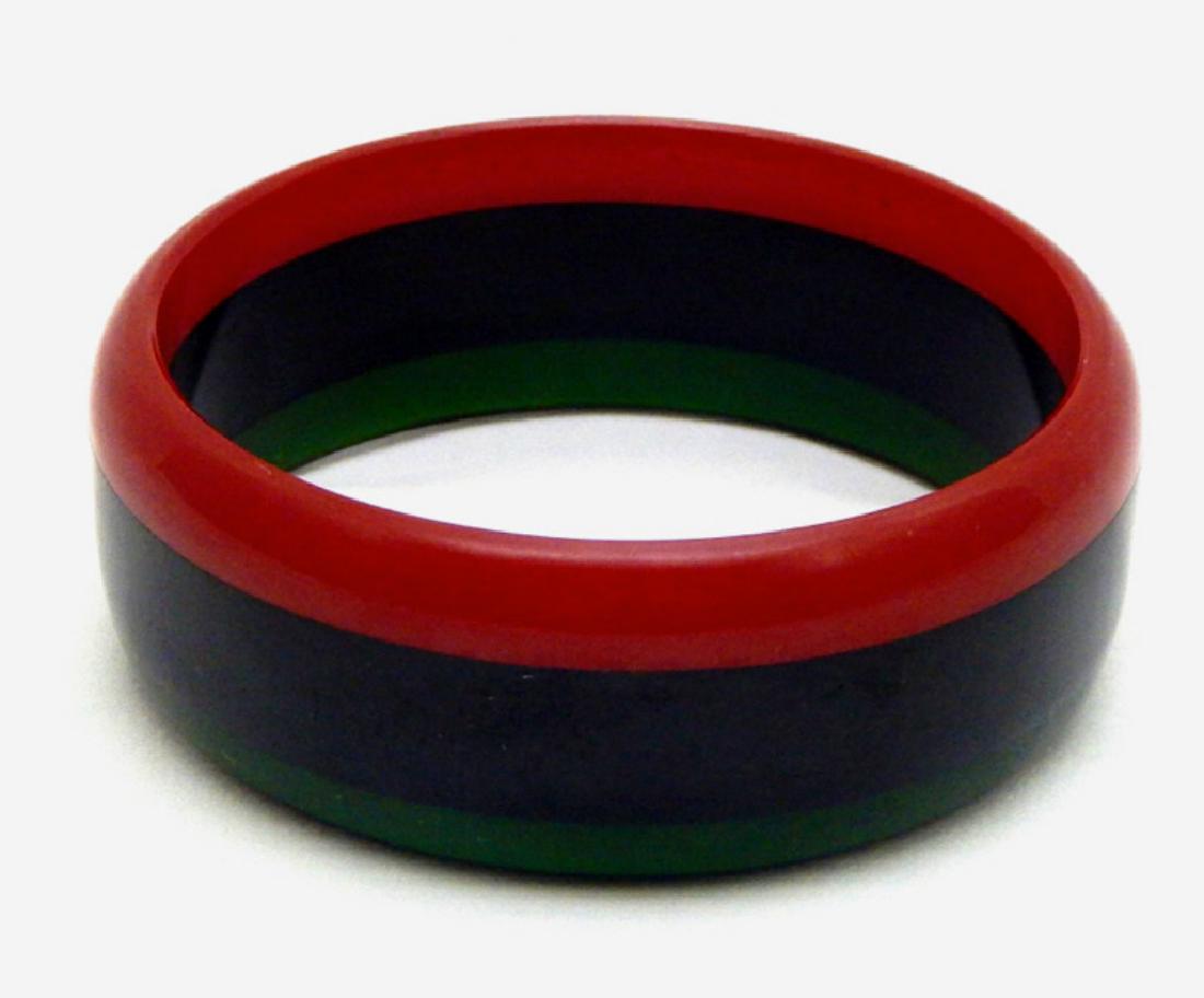 Rare Red, Black & Green Bakelite Bangle, c1930s: Beautiful black, red and green Bakelite bangle in great striped pattern. Measures 3". Bakelite was tested. Estimate $200 - $250 Starting Bid $50