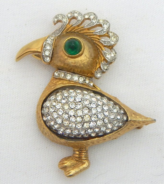 Kenneth Jay Lane Dodo Bird Day/Night Brooch: Rotating middle section green stones to crystals. Signed "K. J. Lane". Measures 2 1/2" x 2". Estimate $100 - $200 Starting Bid $20
