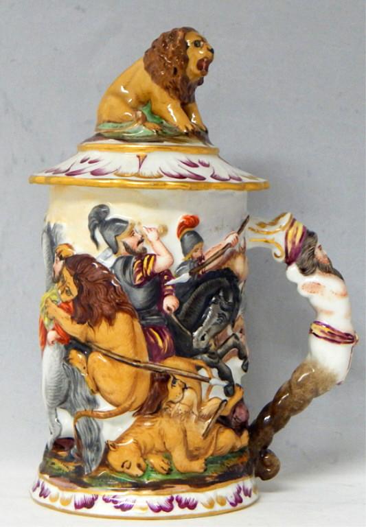 Capodimonte Hunting Scene Stein w/ Lion on Lid: Raised colorful battle scene of man vs lion with figural handle and lion on lid. Measures 7". Makers mark on bottom. Estimate $100 - $150 Starting Bid $20