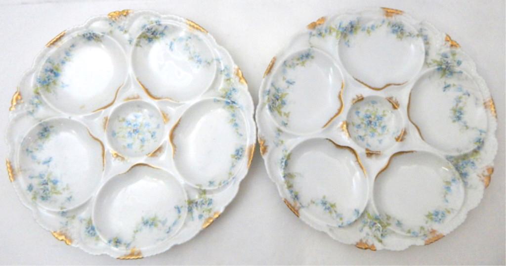2 Theodore Haviland Limoges Oyster Plates, c1890: Hand painted with tiny blue and green flowers and gold trim. Has five oyster wells and one sauce well. Marked "Porcelaine Theodore Haviland Limoges France". Great Condition. Measures 8 1/2". Estimate 