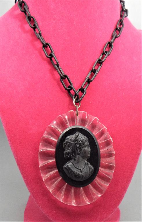 Black Bakelite Cameo on Lucite with Bakelite Chain: Measures 16". Estimate $50 - $100 Starting Bid $20