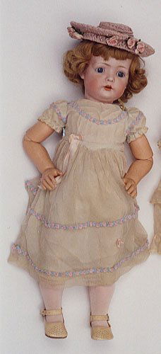 A BRUNO SCHMIDT BISQUE HEAD TODDLER DOLL, circa 19: A BRUNO SCHMIDT BISQUE HEAD TODDLER DOLL, circa 1910, blue glass eyes, open mouth with incised teeth, blonde wig, on ball-jointed composition body, well dressed. Marked B S W in heart, #2097, height 2