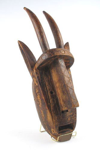 AN AFRICAN DOGON FACE MASK, Mali, hand carved with: AN AFRICAN DOGON FACE MASK, Mali, hand carved with incised and stamped decoration, an elongated nose and twin curved horns. Height 23 1/2 in. c. 1920's. Acquired in Timbuktu in what used to be French